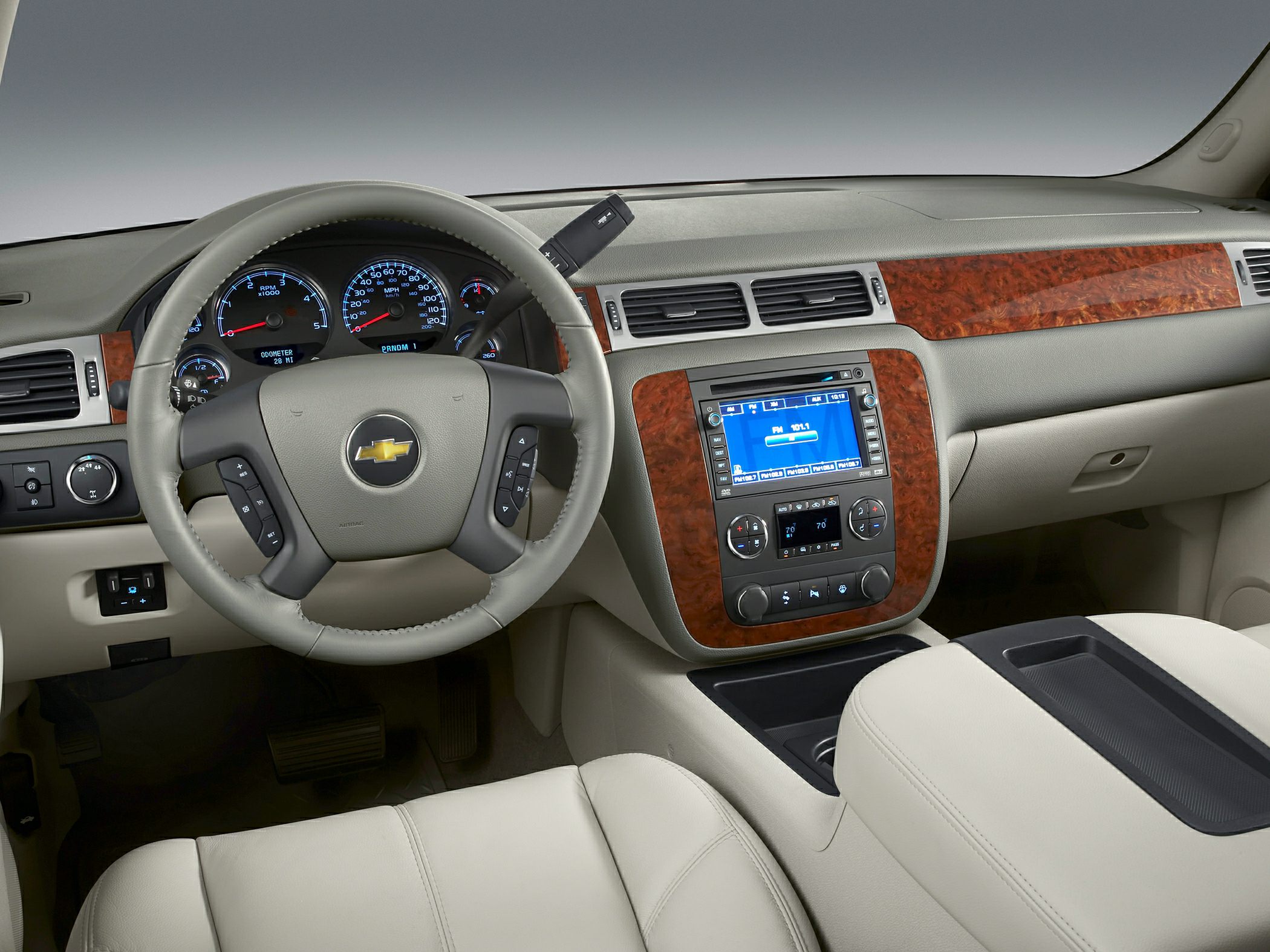 Dashboard with wood trim and digital display, steering wheel with controls.