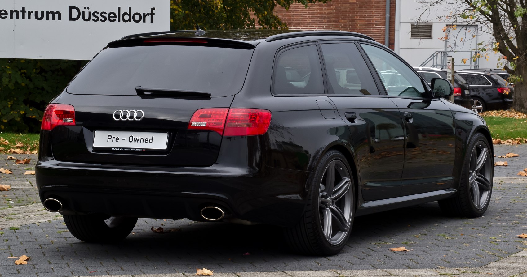 Black estate car rear with dual exhausts and sporty wheels
