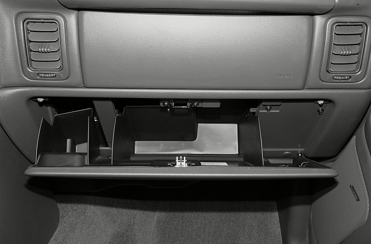 Open glove box and dashboard air vents in a vehicle interior