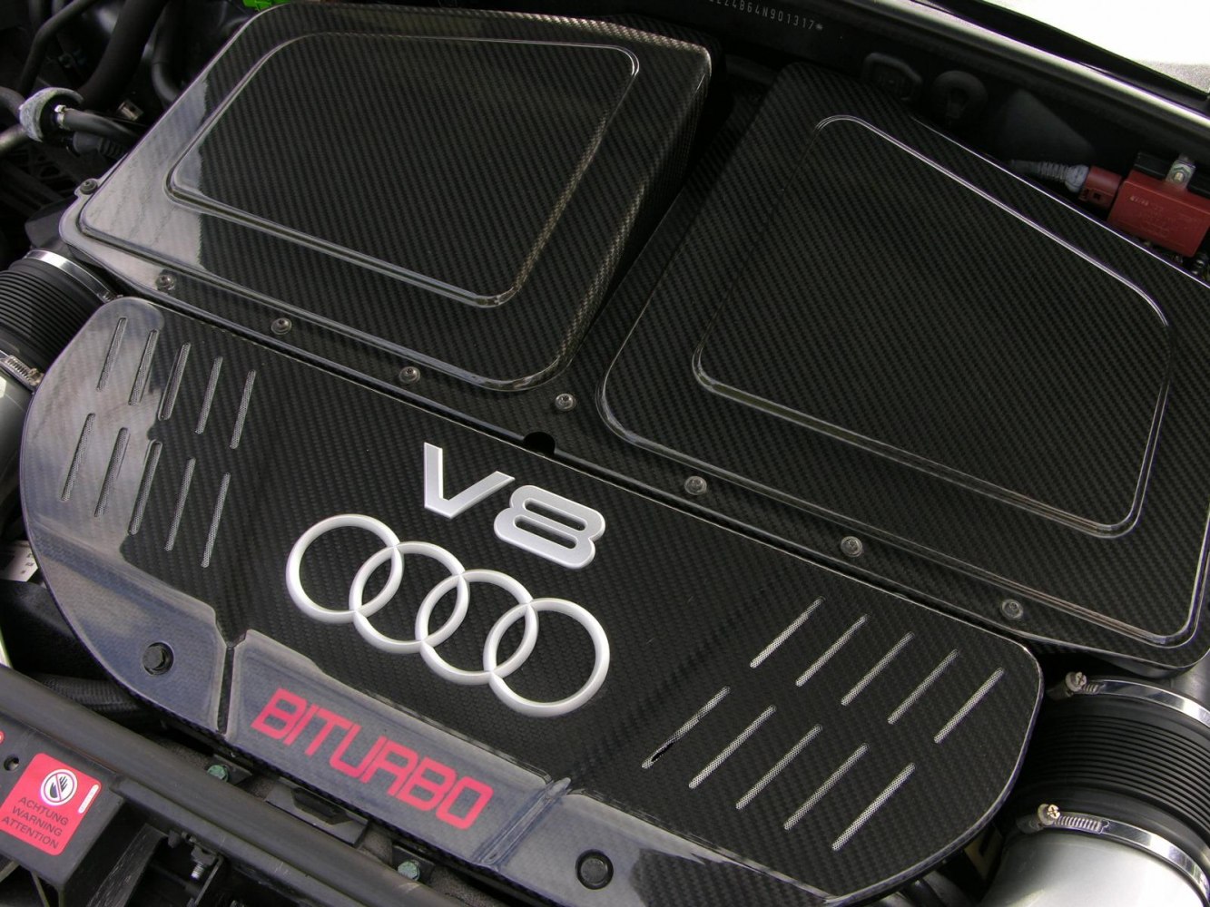 Close-up of a V8 biturbo engine with carbon fiber cover