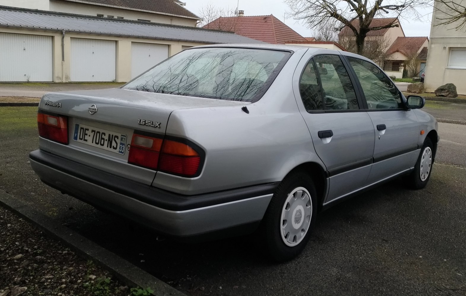 Rear view of a sedan with 1.6 SLX badge and classic taillights