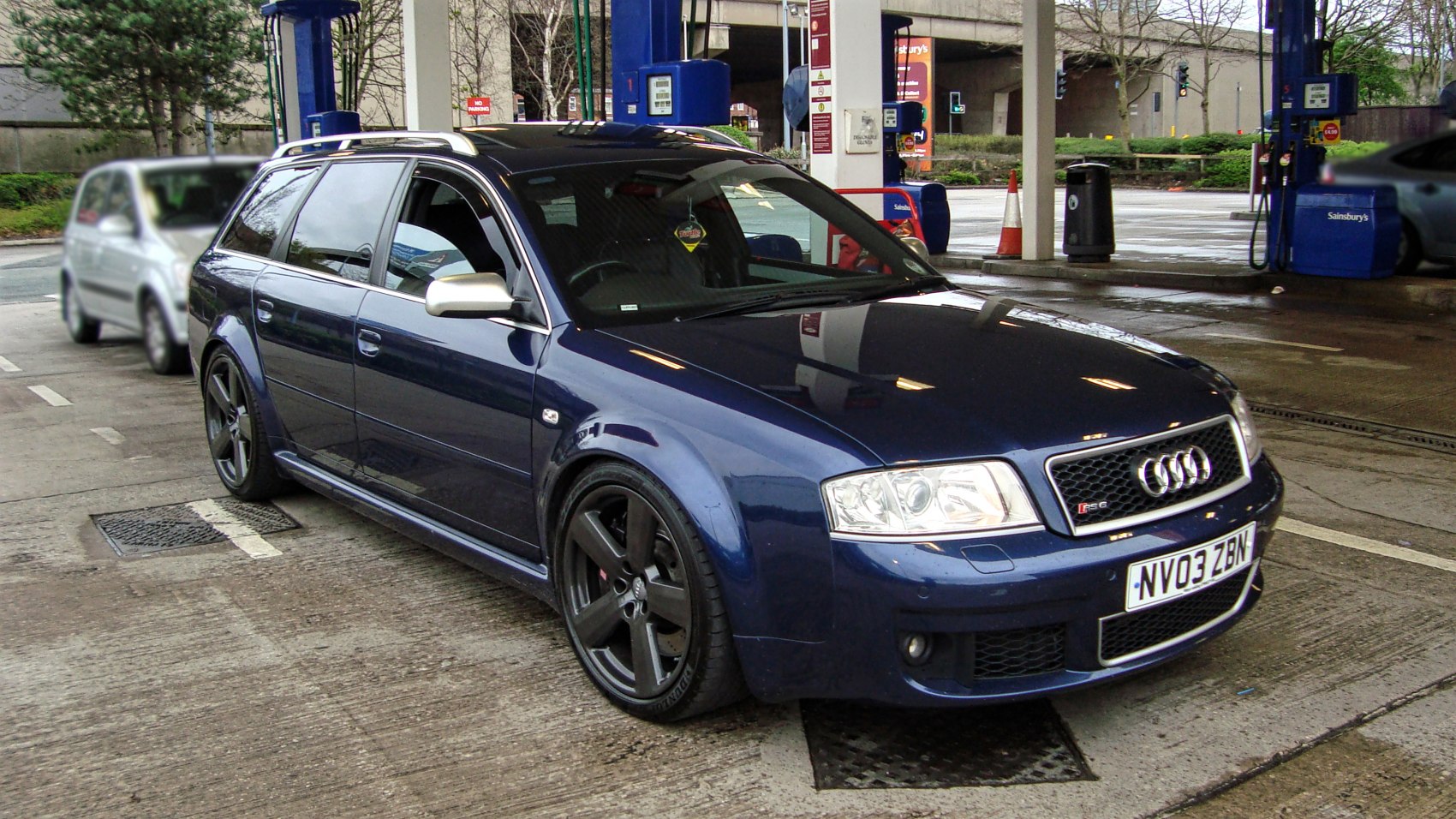Blue station wagon with black five-spoke alloy wheels and roof rails