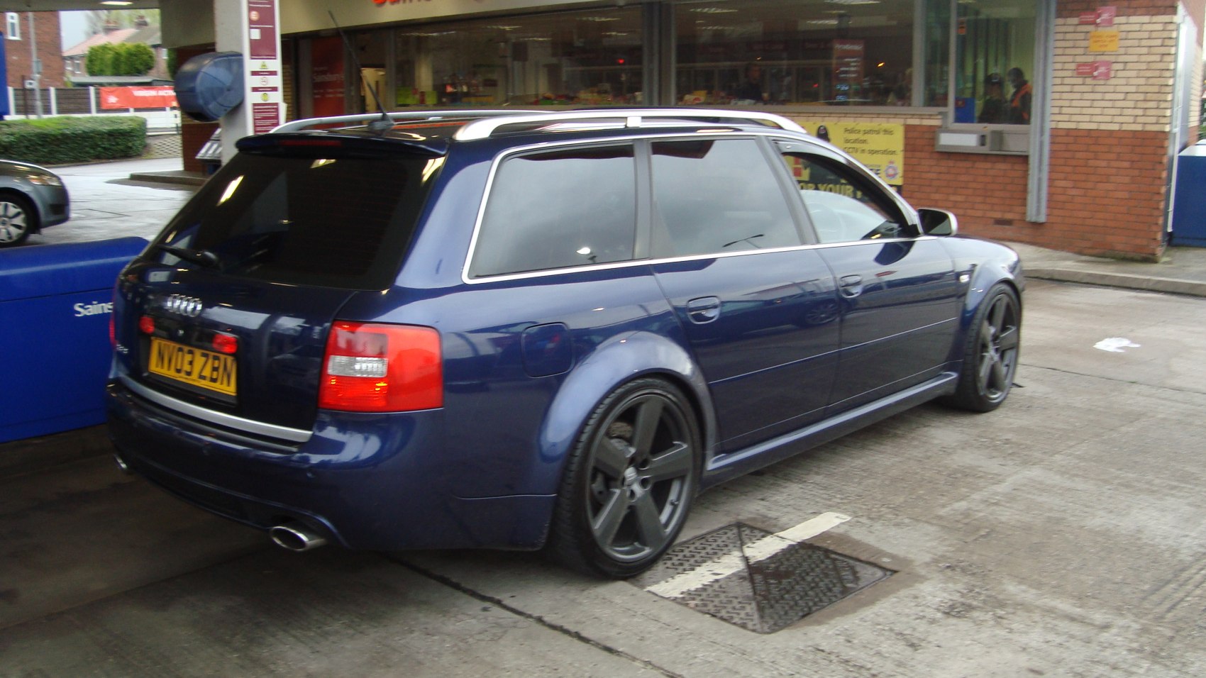 Rear view of sporty station wagon with black wheels and dual exhaust