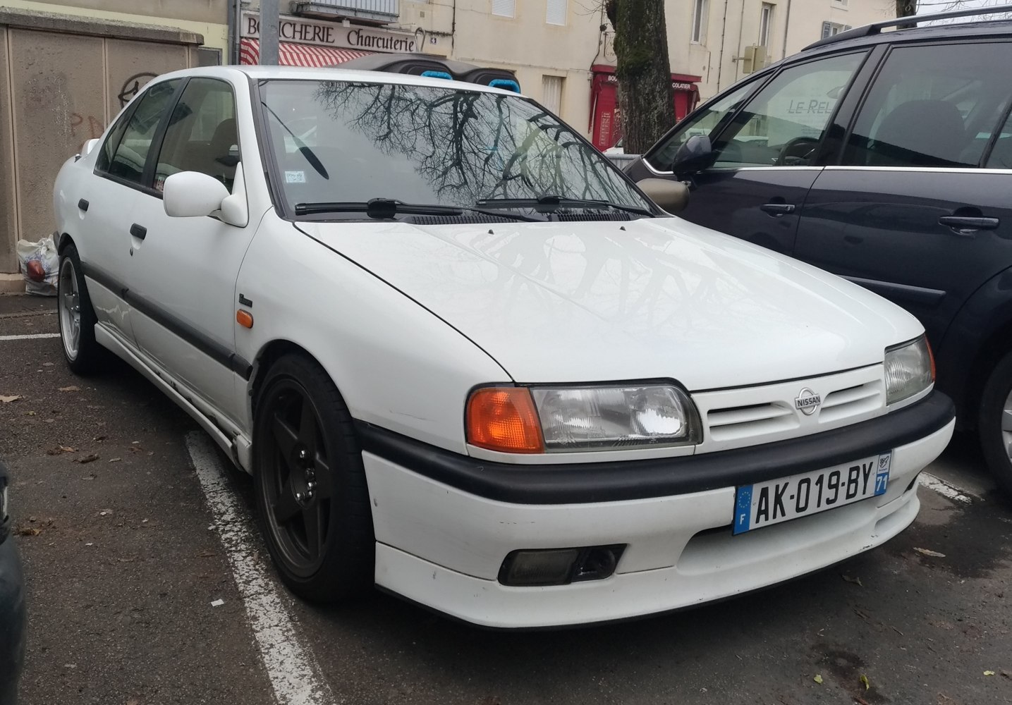 White sedan with black wheels and front lip spoiler