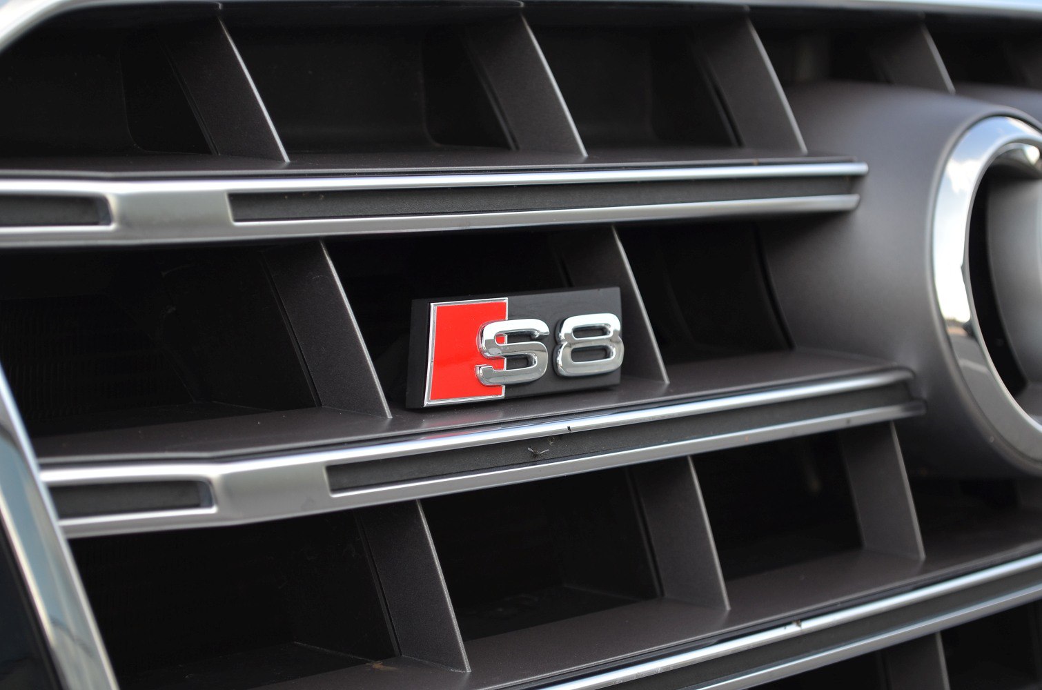 Close-up of Audi S8 grille emblem with chrome and black trim