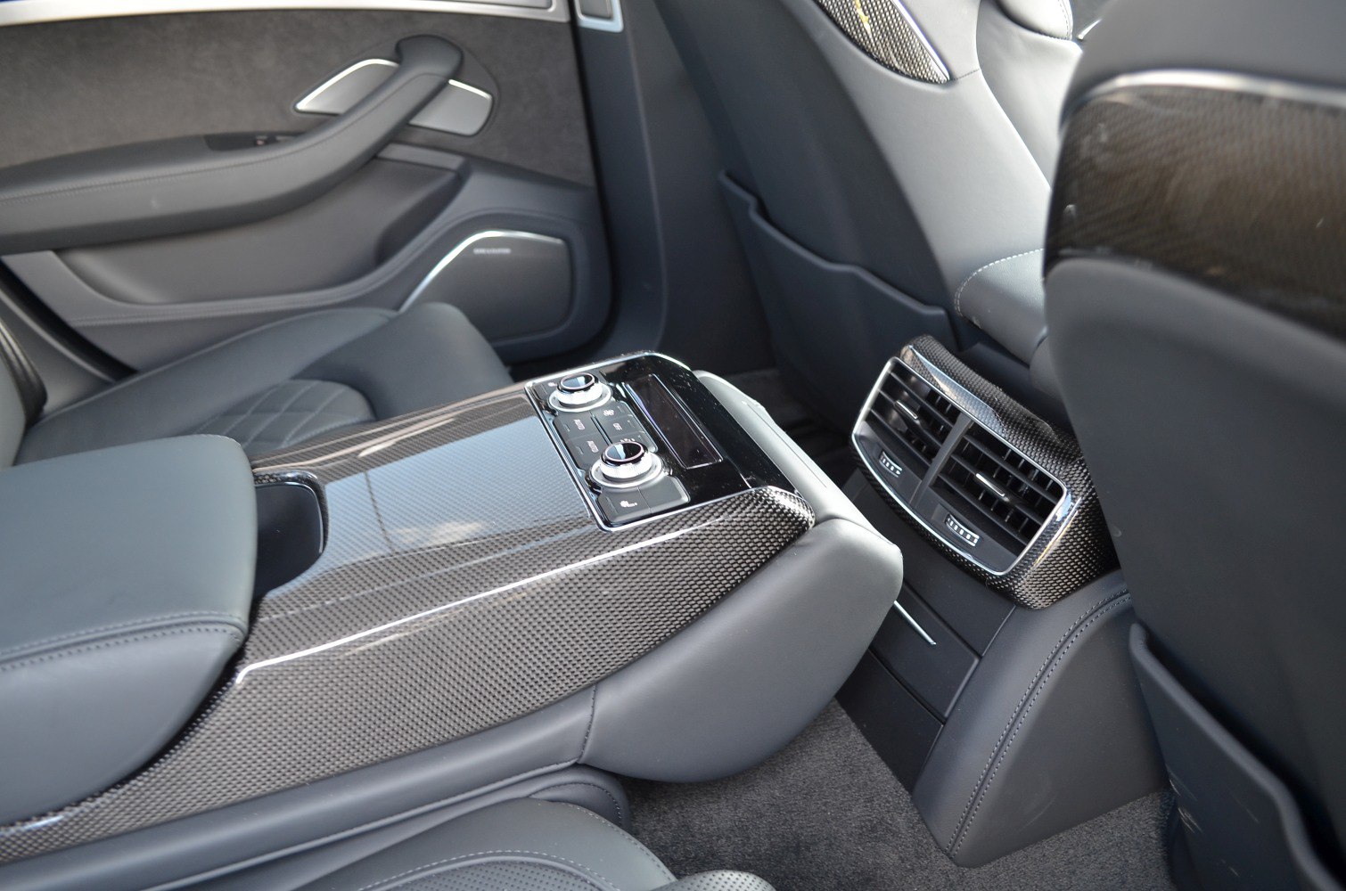 Rear interior with carbon fiber trim and advanced seat controls.