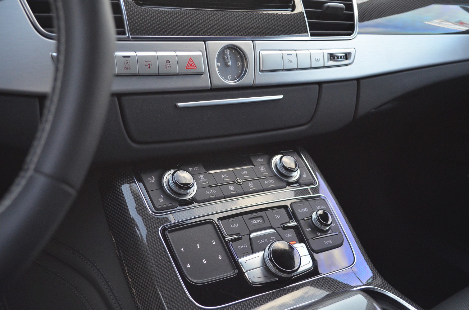 Luxury car center console with climate controls and analog clock