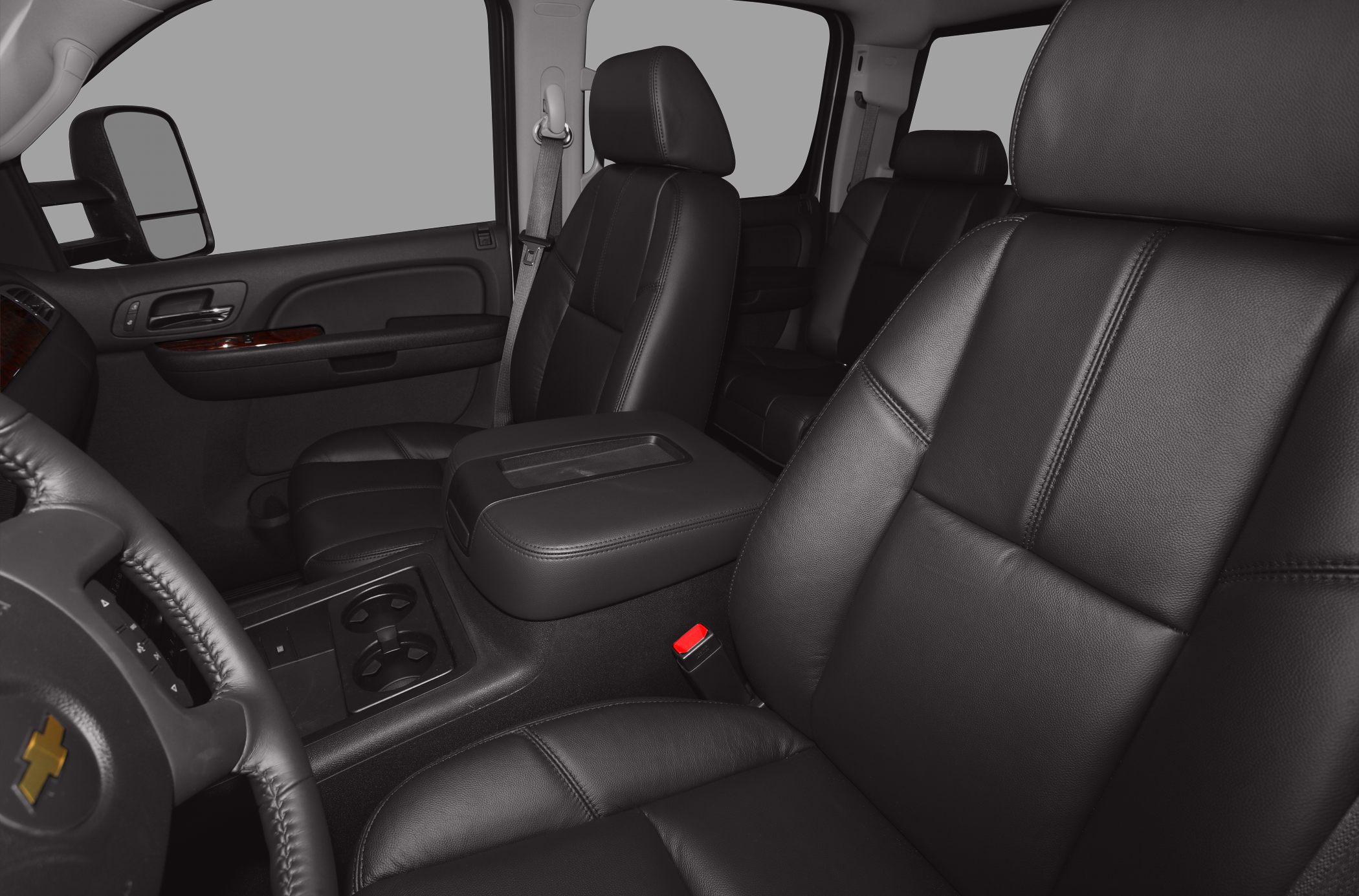 Black leather seats and center console with cup holders in a crew cab truck interior