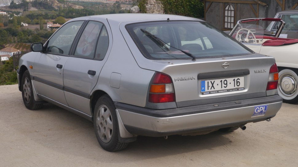 Rear view of a 1990s hatchback sedan with tail lights and rear windshield wiper