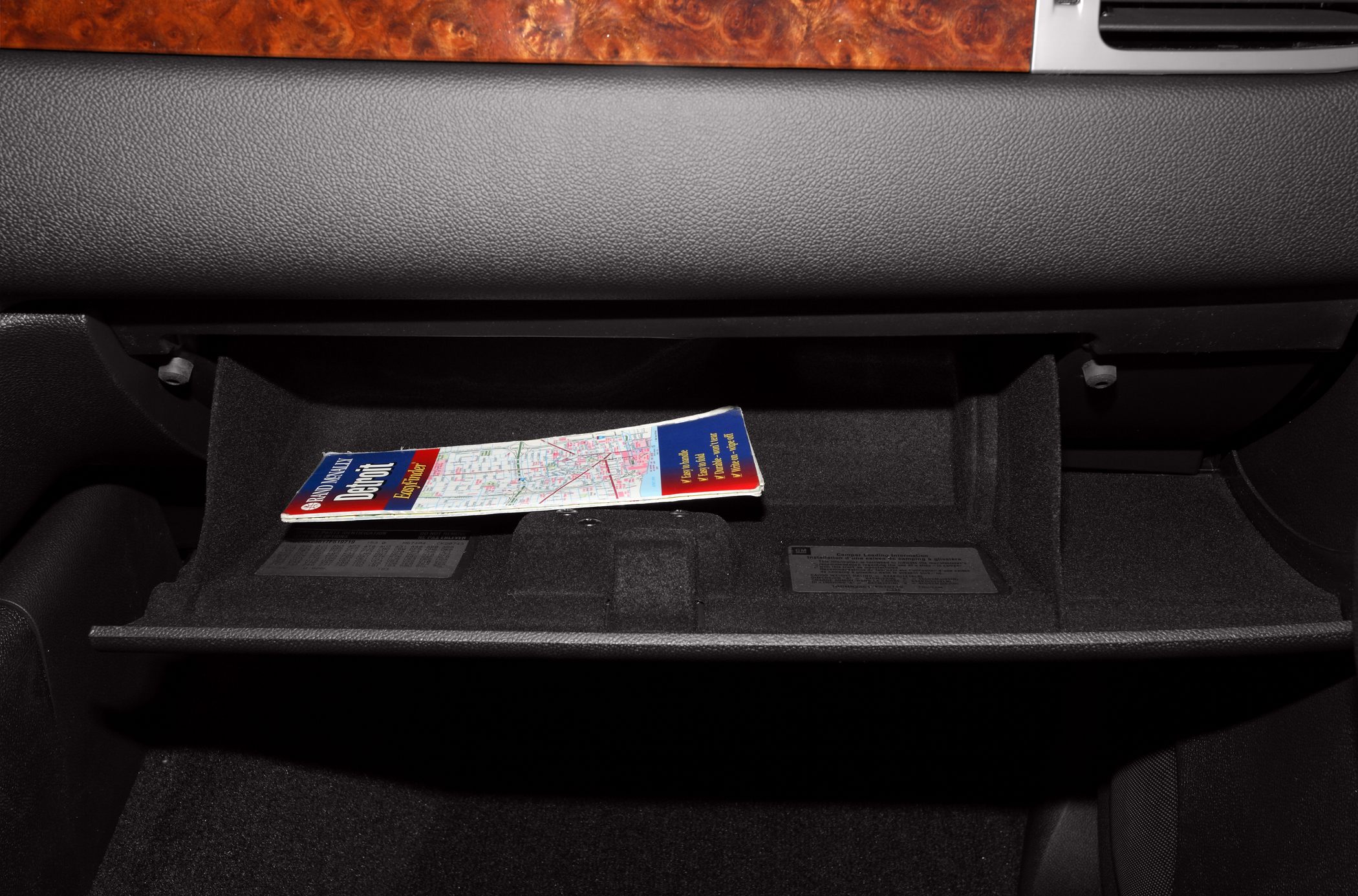 Glove box compartment with storage space and folded map inside vehicle