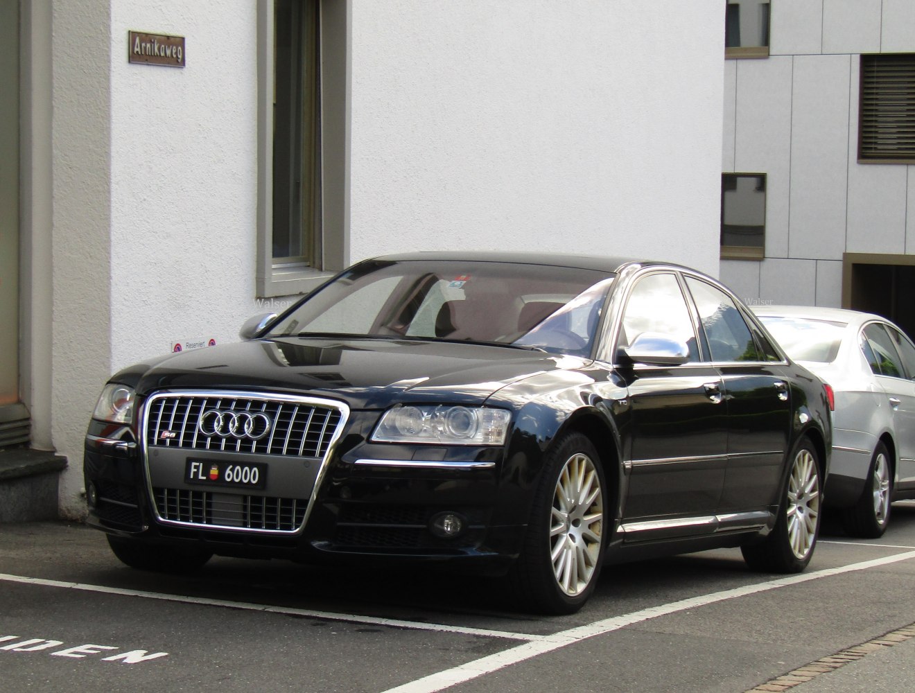 Black luxury sedan with vertical grille and clear headlights