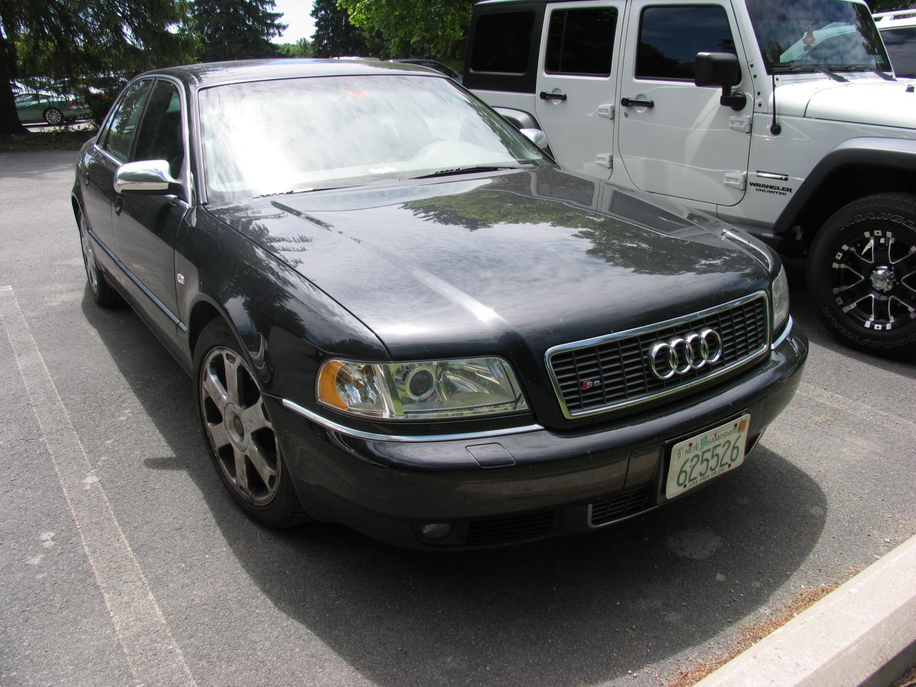 Front angle of classic luxury sedan with grille, headlights, alloy wheels