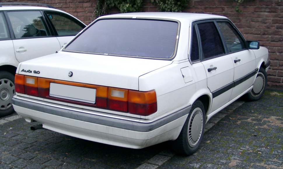 Rear exterior view of a white 1980s sedan with distinctive tail lights and boxy design