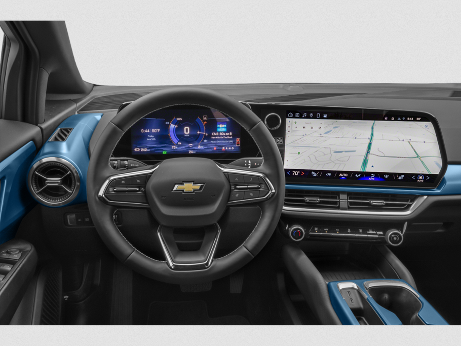 Dual digital screens, steering wheel with controls, modern EV cockpit interior