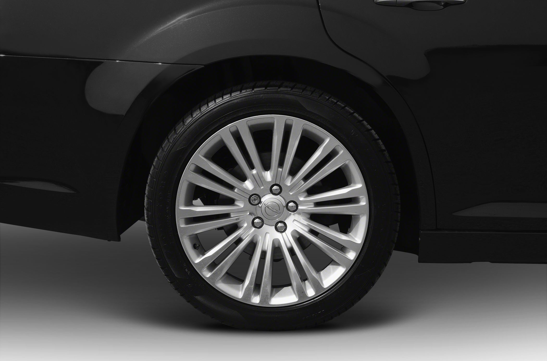 Detailed close-up of a multi-spoke alloy wheel on a black vehicle.