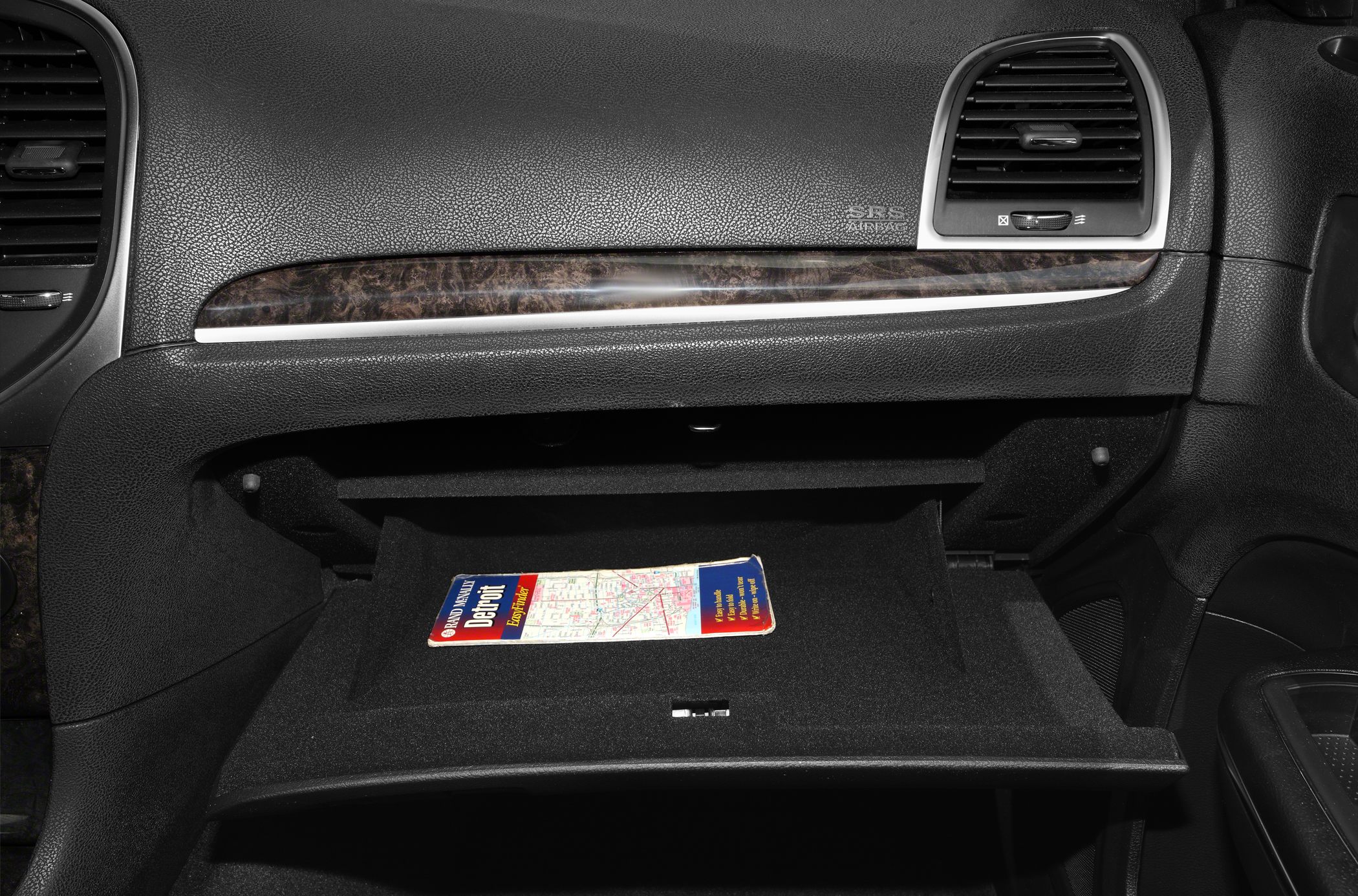 Glove box interior with a dashboard trim and air vent