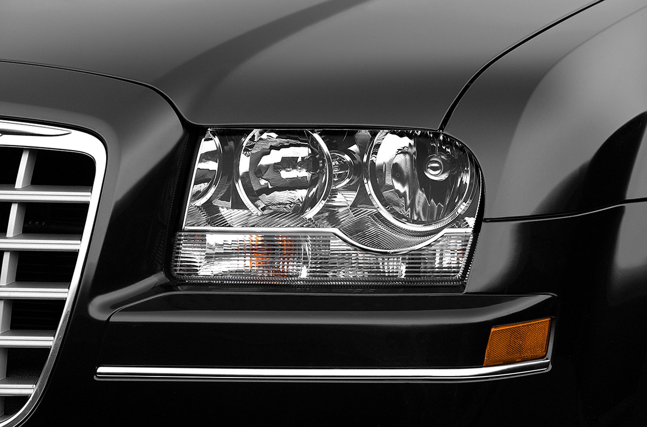 Close-up of dual projector headlights and front grille.