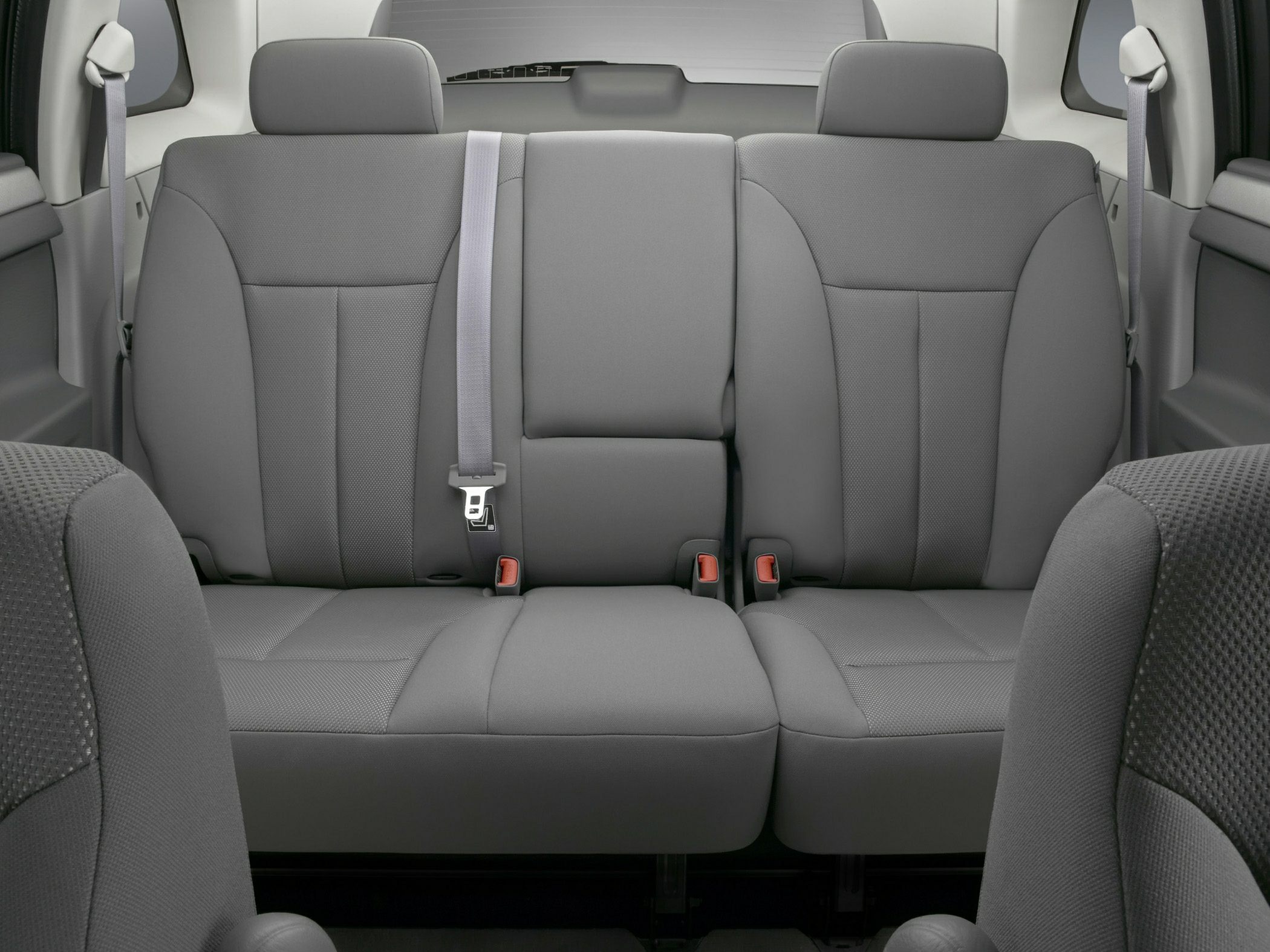 Gray upholstered rear seats with seatbelts in vehicle interior