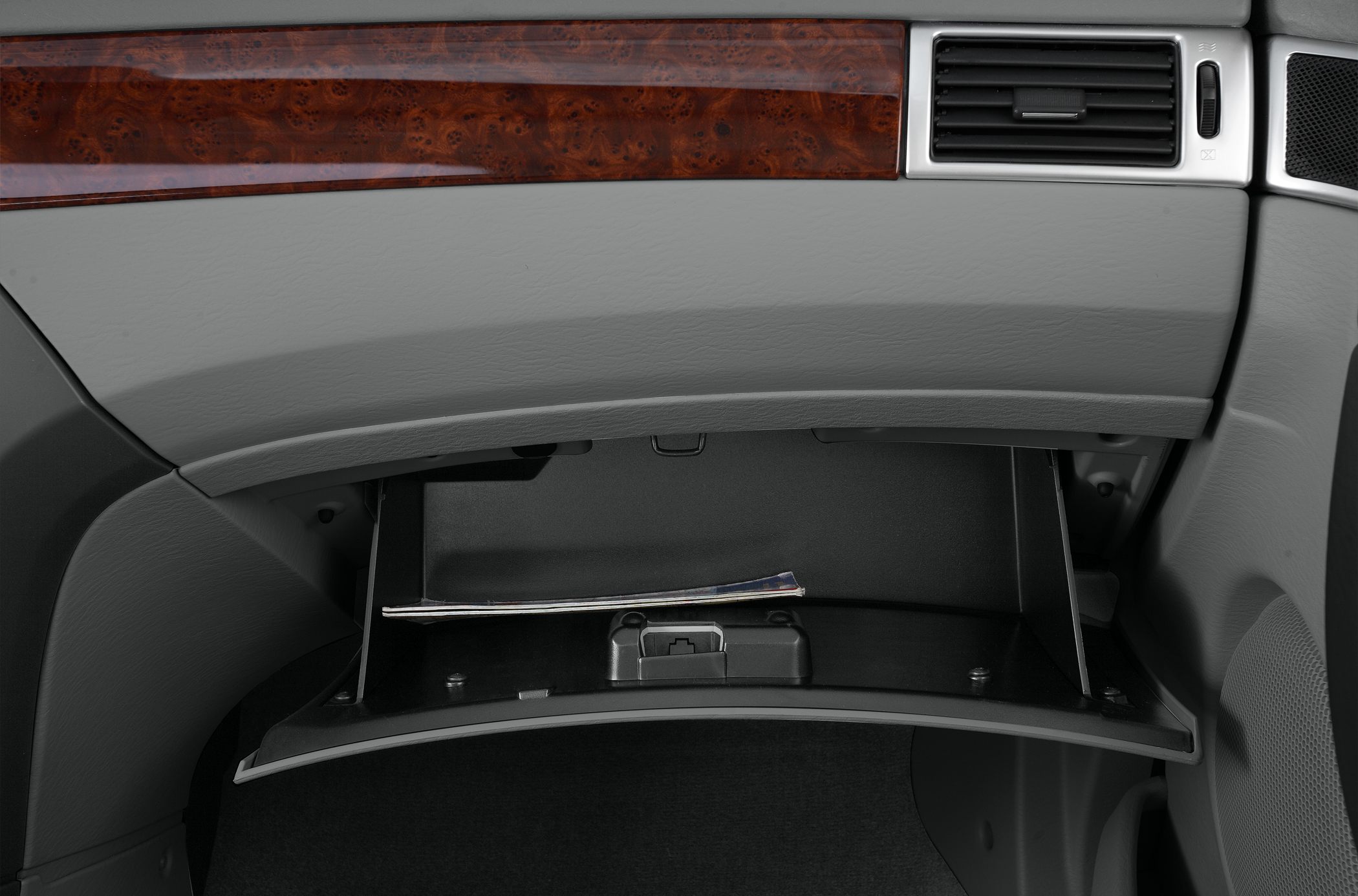 Open glove compartment with wooden trim and air vent panel