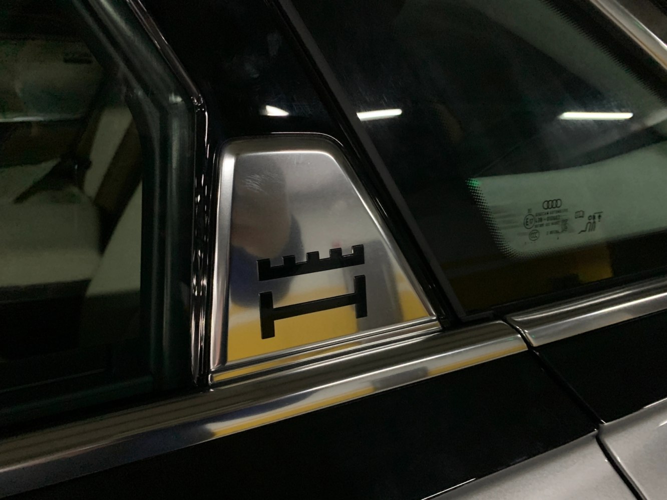 Close-up of rear window triangle trim with emblem