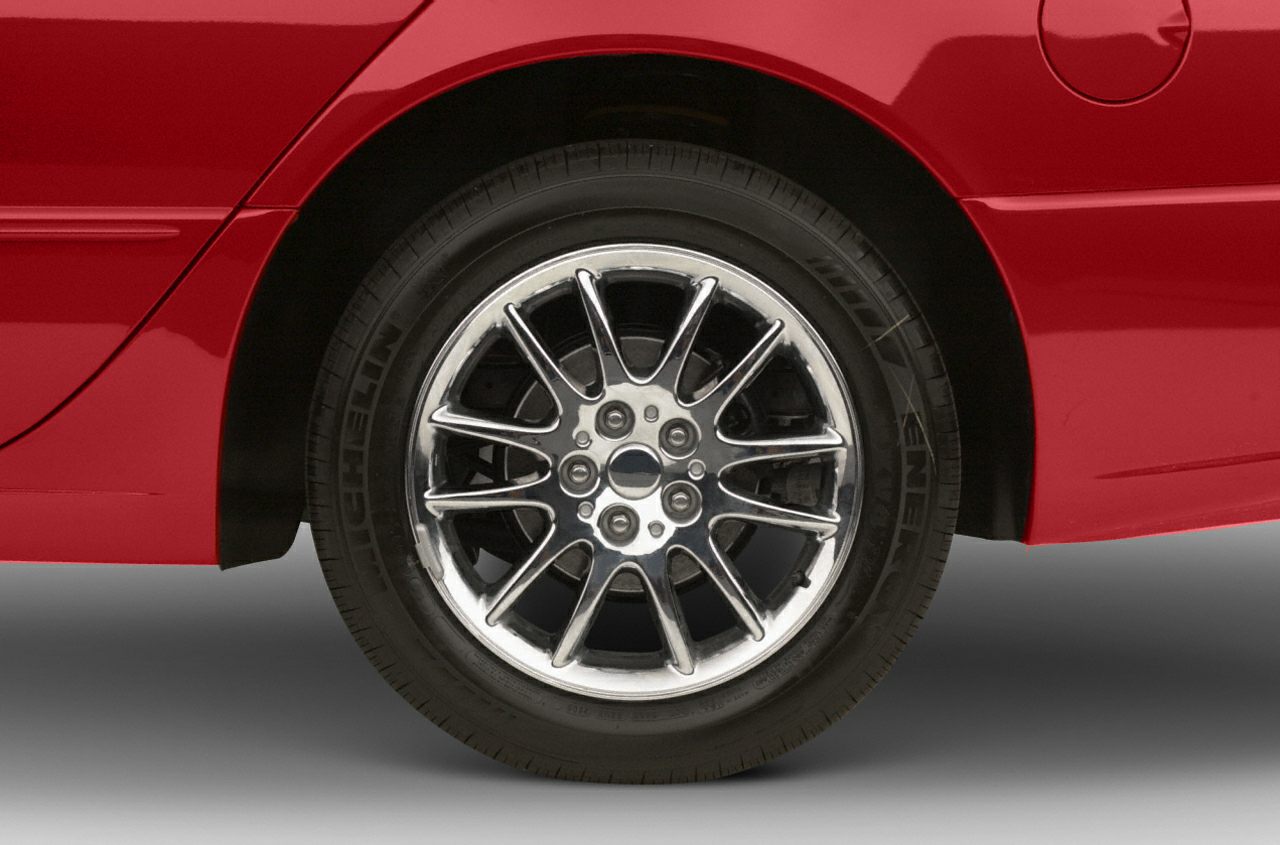 Chrome multi-spoke alloy wheel with Michelin tire on red car panel
