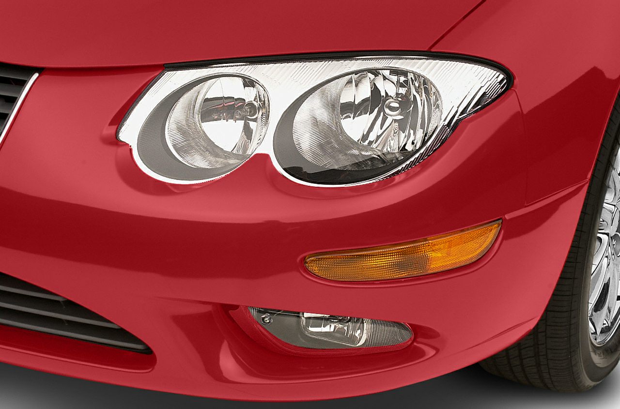 Close-up of dual round headlights and amber signal light on red front bumper