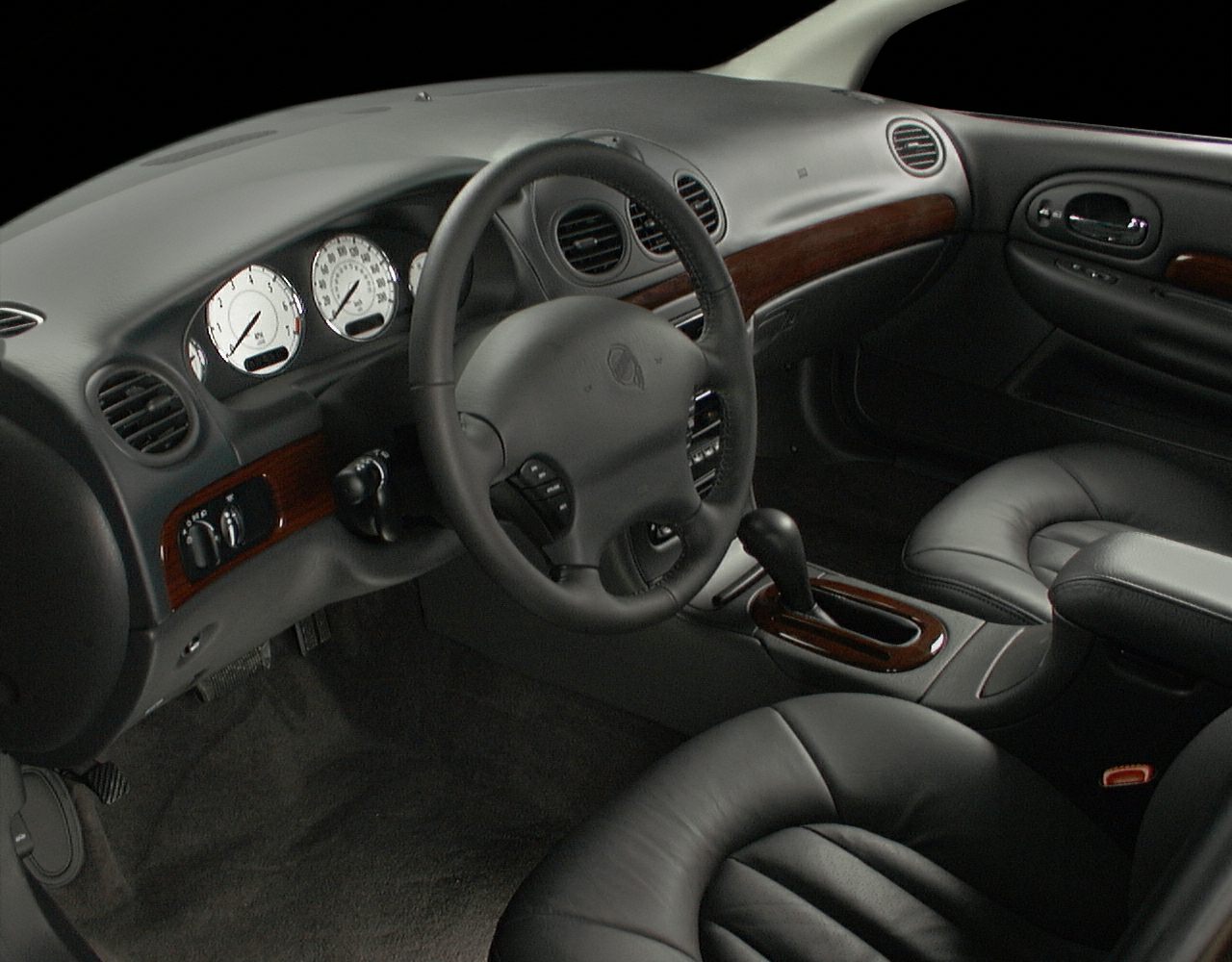Leather seats, wooden accents, dashboard with gauges, steering wheel, automatic gear shift