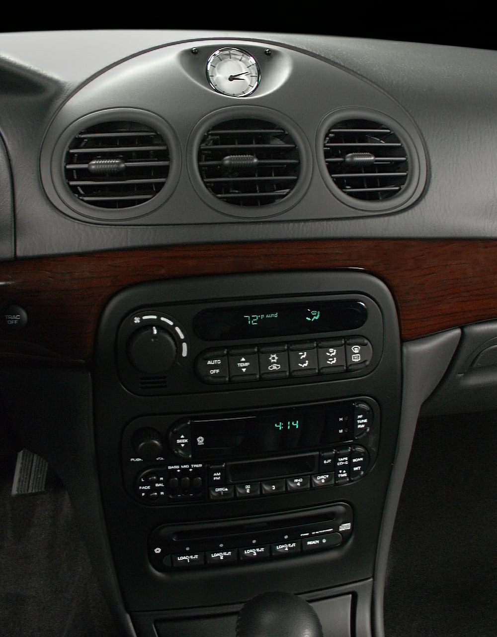 Dashboard with analog clock, air vents, and climate control panel