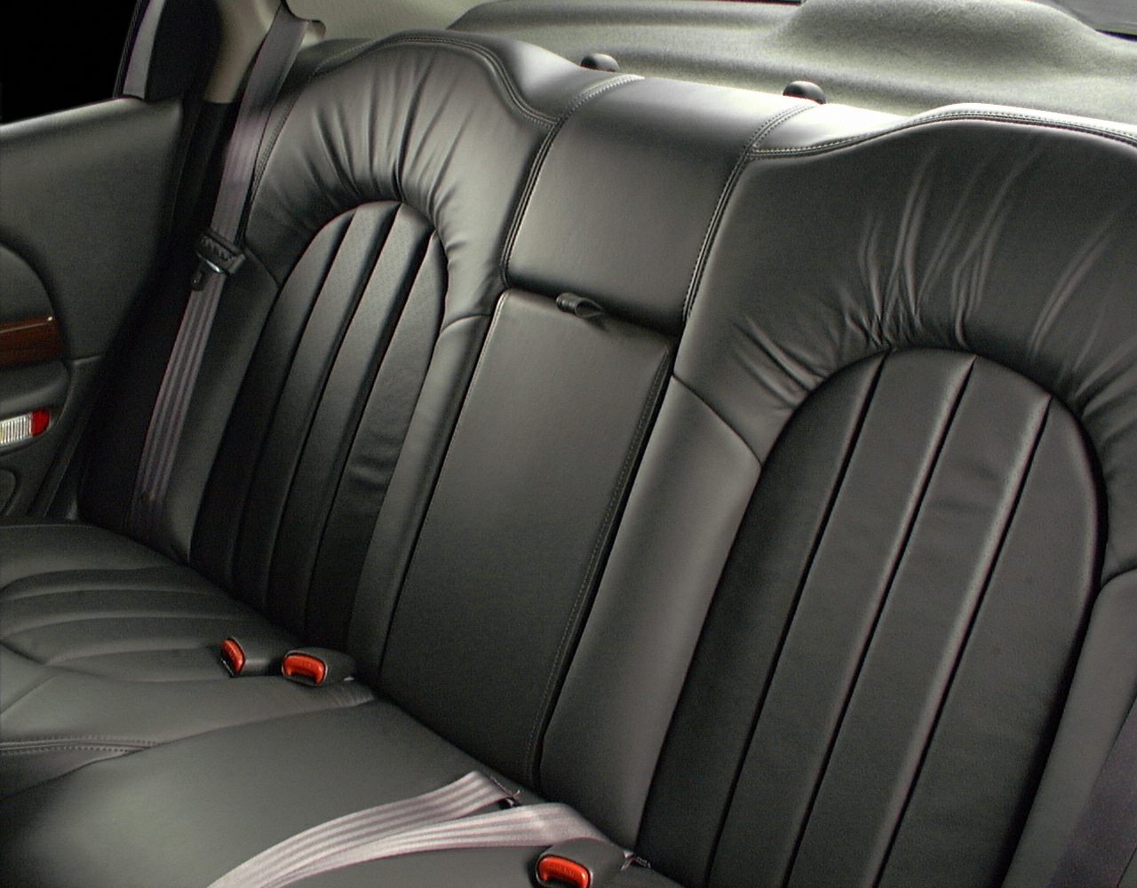 Black leather rear seat with center armrest and seatbelts