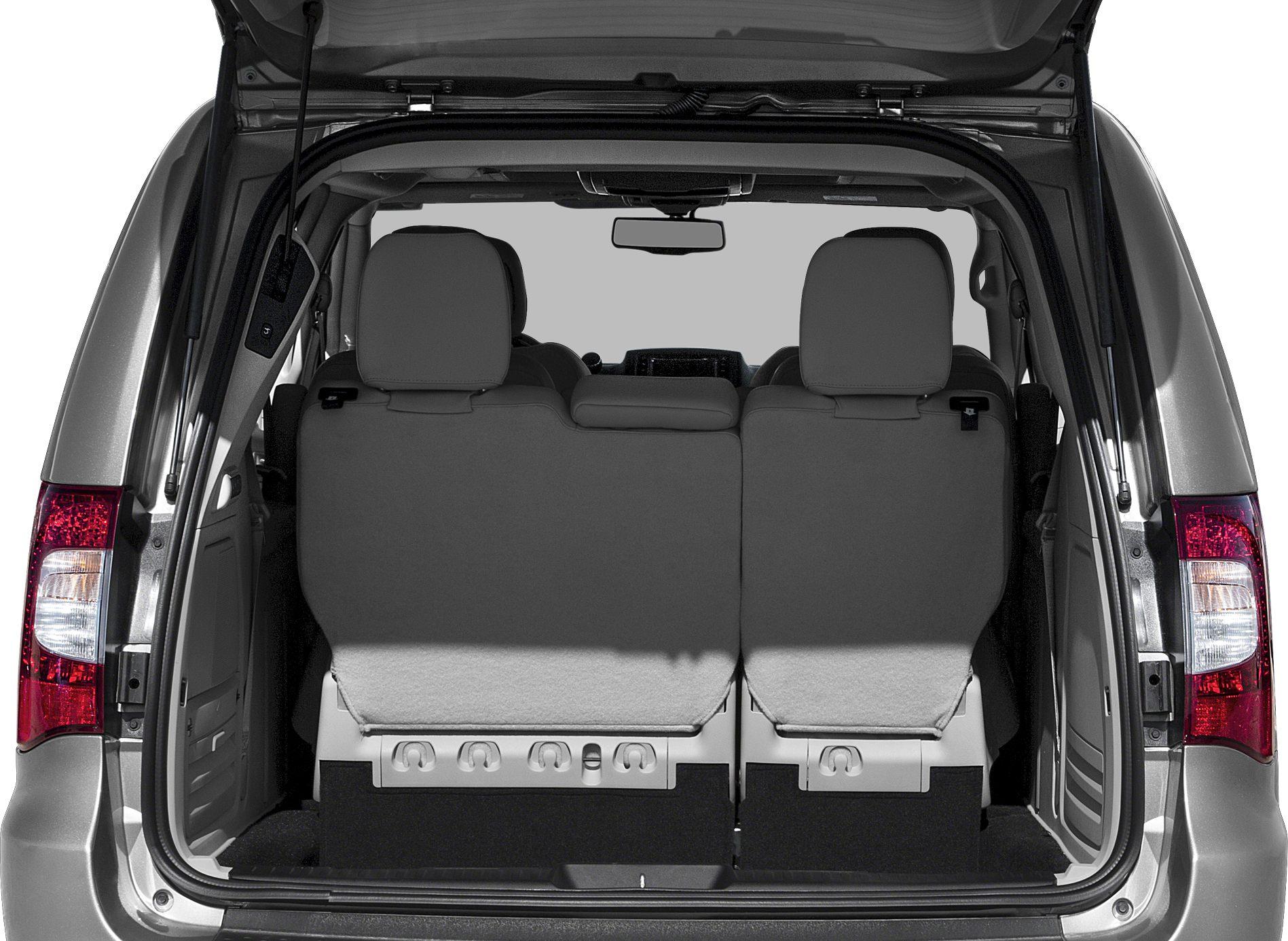 Open tailgate with upright third row seats inside minivan rear.