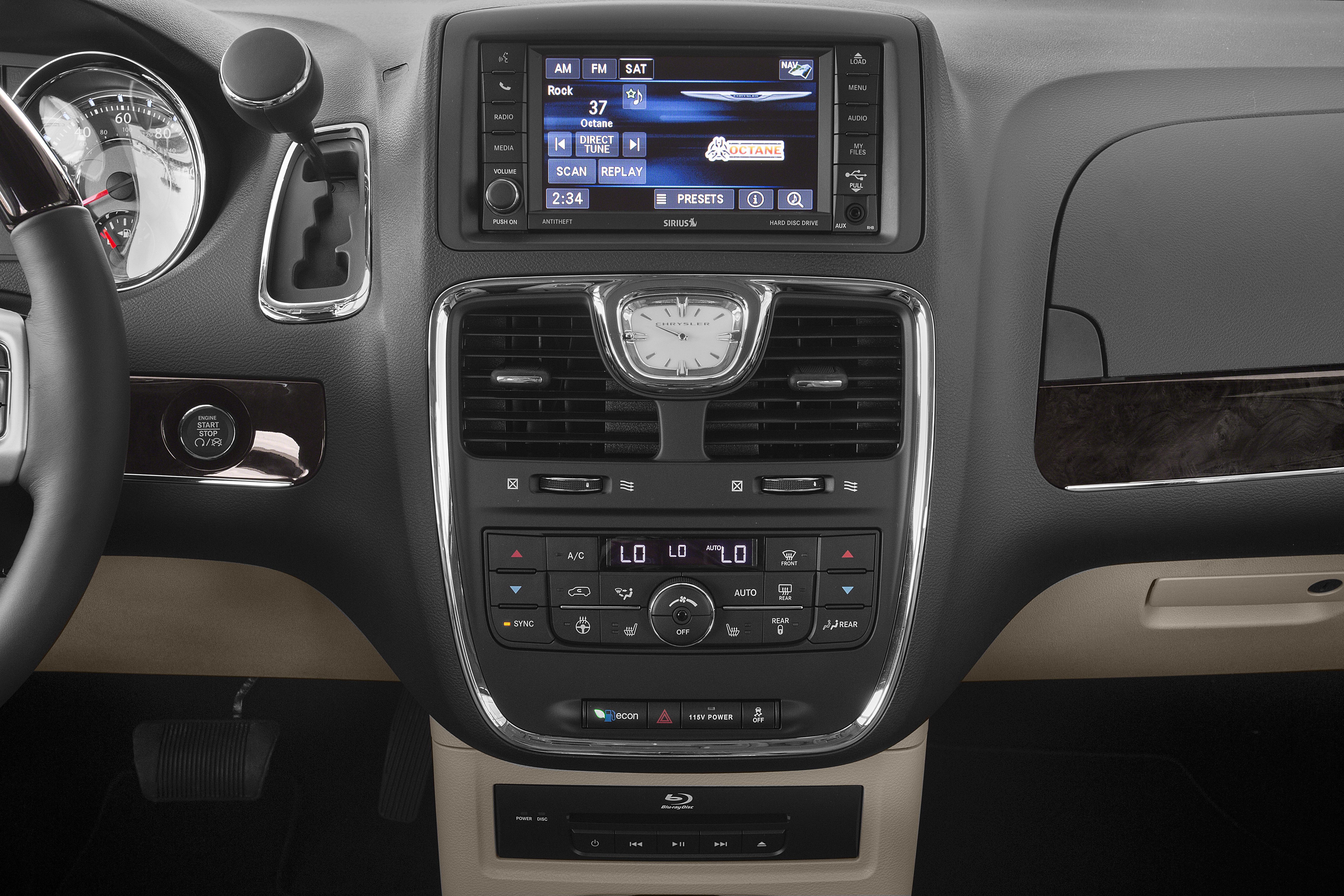 Infotainment screen, analog clock, climate control panel in vehicle dashboard