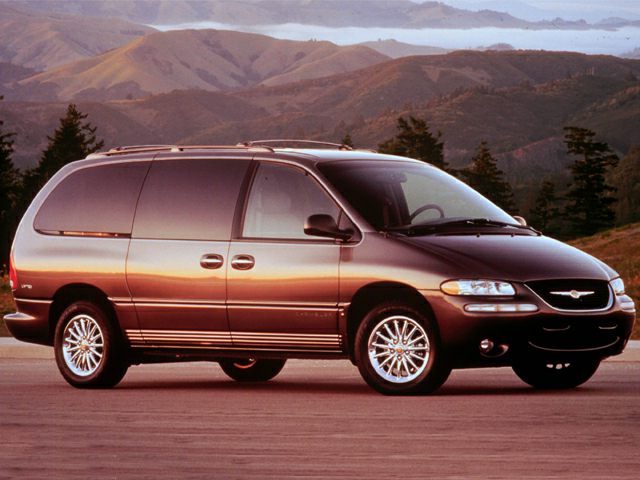Front side profile of a minivan with sliding doors and alloy wheels.
