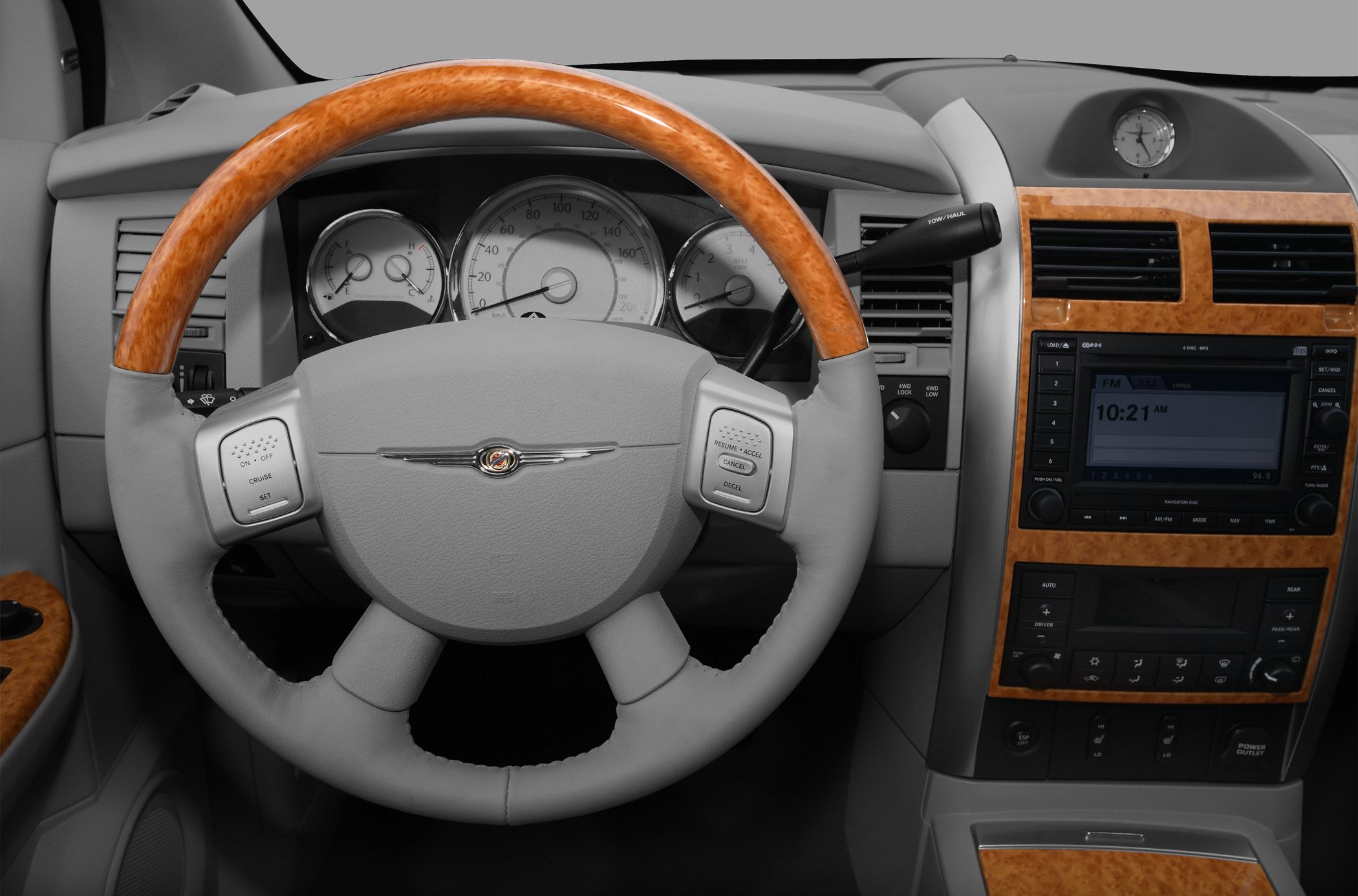 Wood-trimmed steering wheel and detailed dashboard with infotainment and climate controls