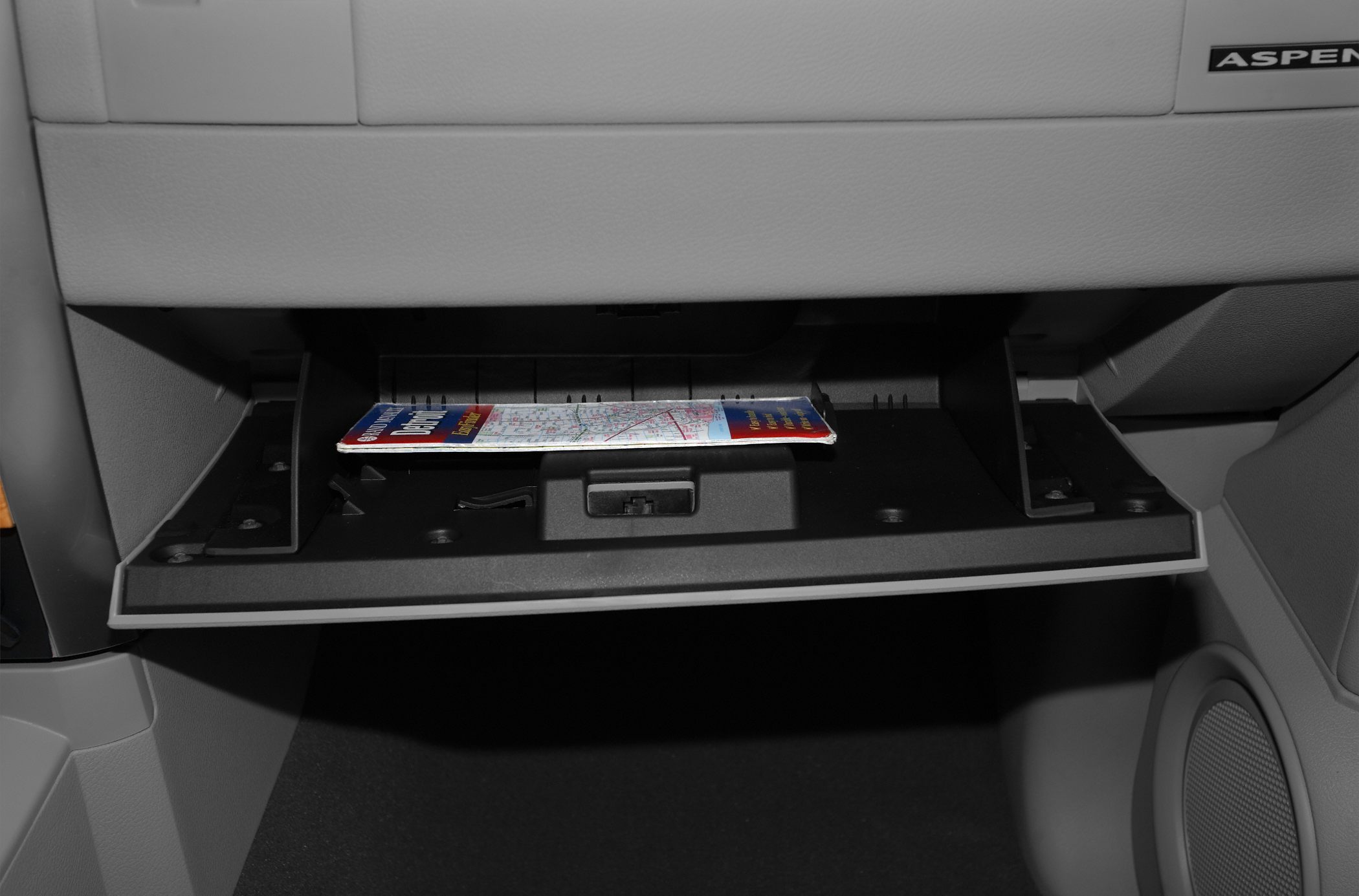 Open glove compartment with map and clean interior paneling