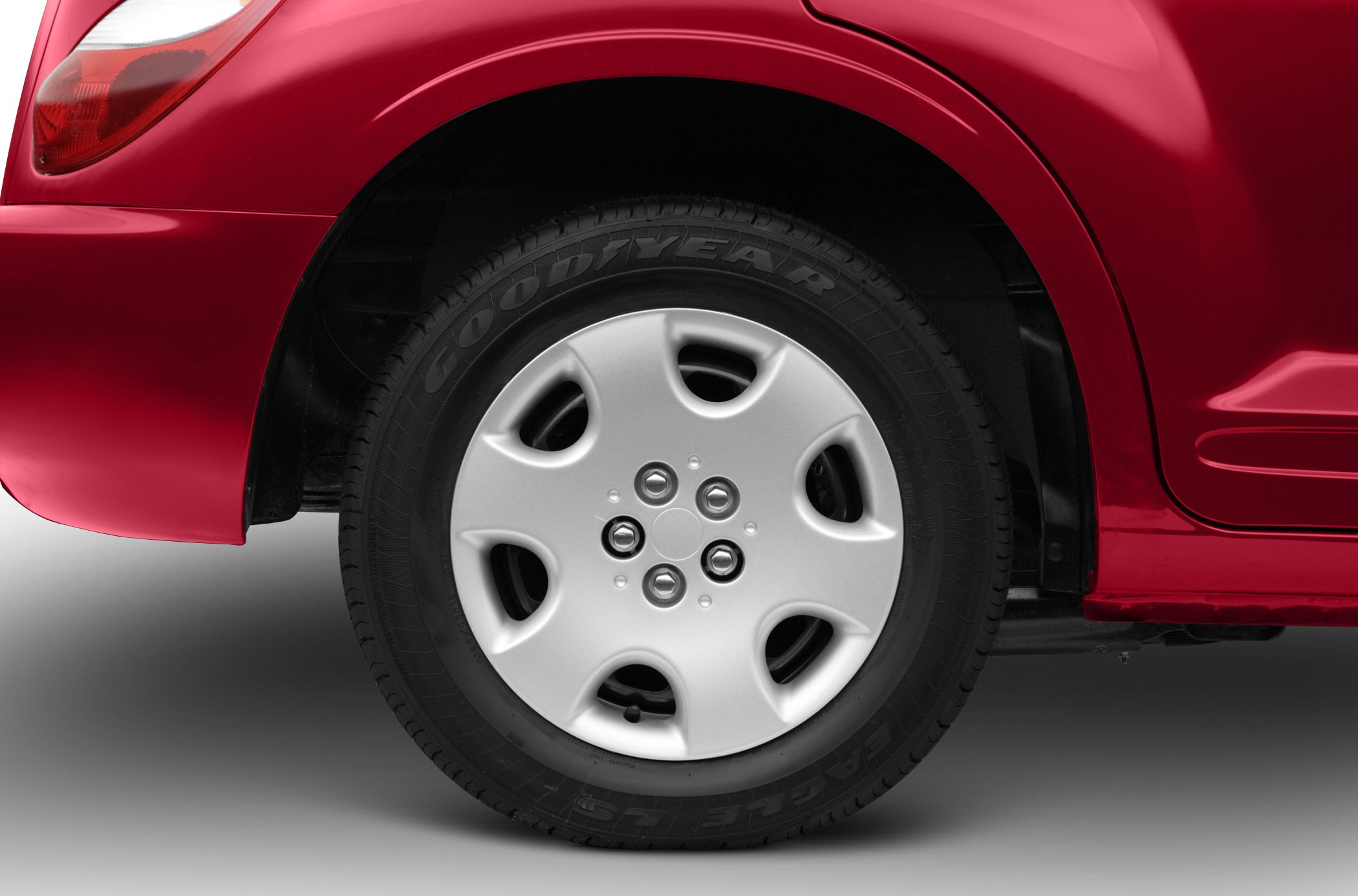 Close-up of silver hubcap and Goodyear tire on vehicle's rear side.