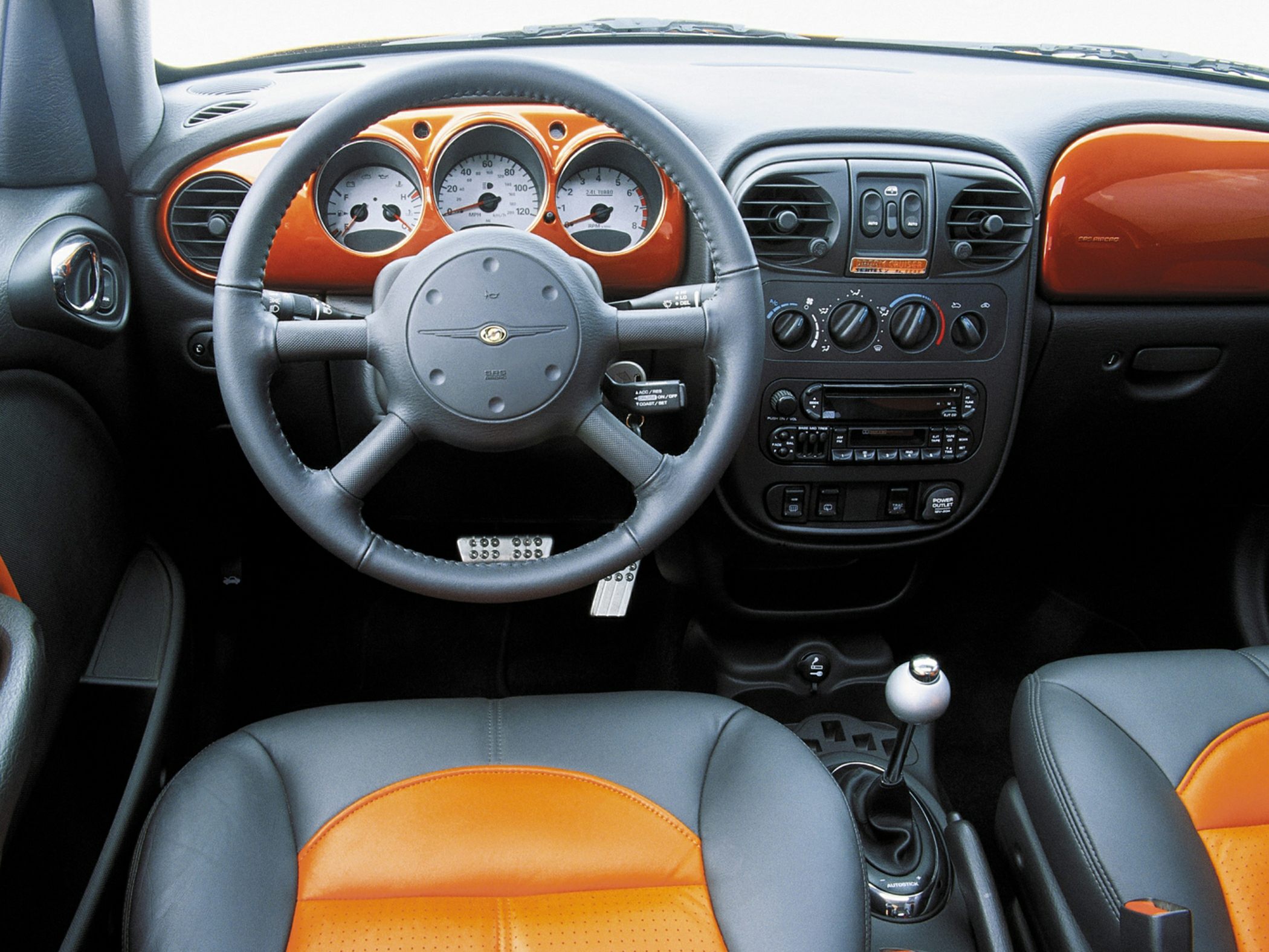 Dashboard with retro gauges, steering wheel, manual shifter, and two-tone seats.