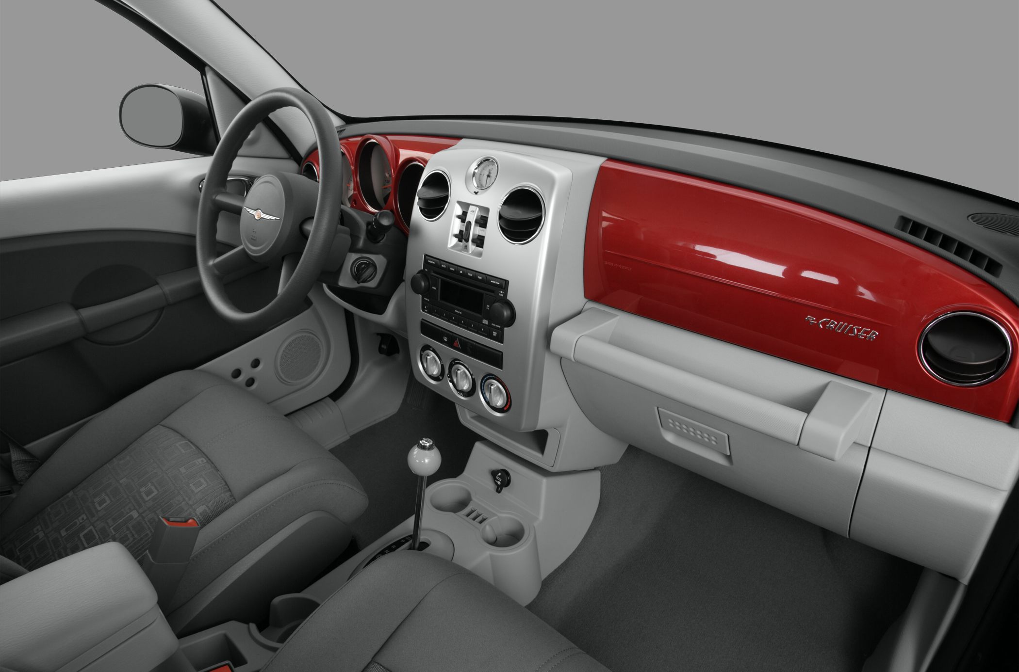 Red dashboard trim and manual gear shift inside car interior