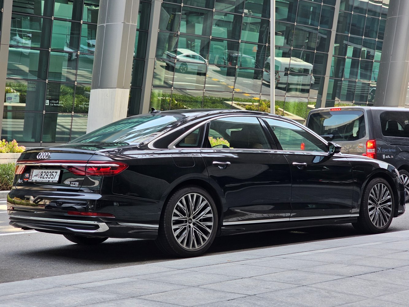 Rear side view of a luxury sedan with LED taillights and multi-spoke alloy wheels.