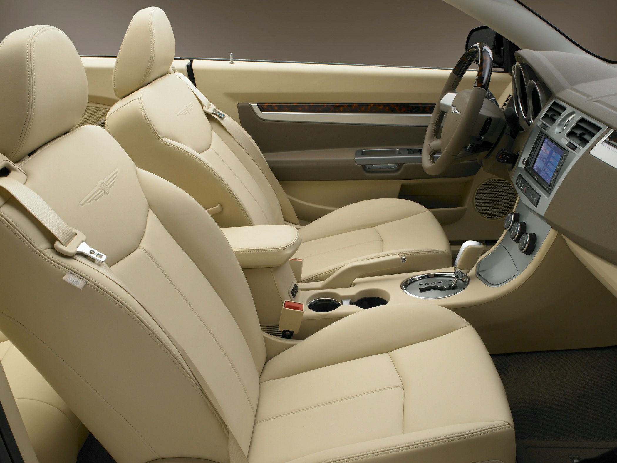 Beige leather seats and dashboard with infotainment system in convertible cabin