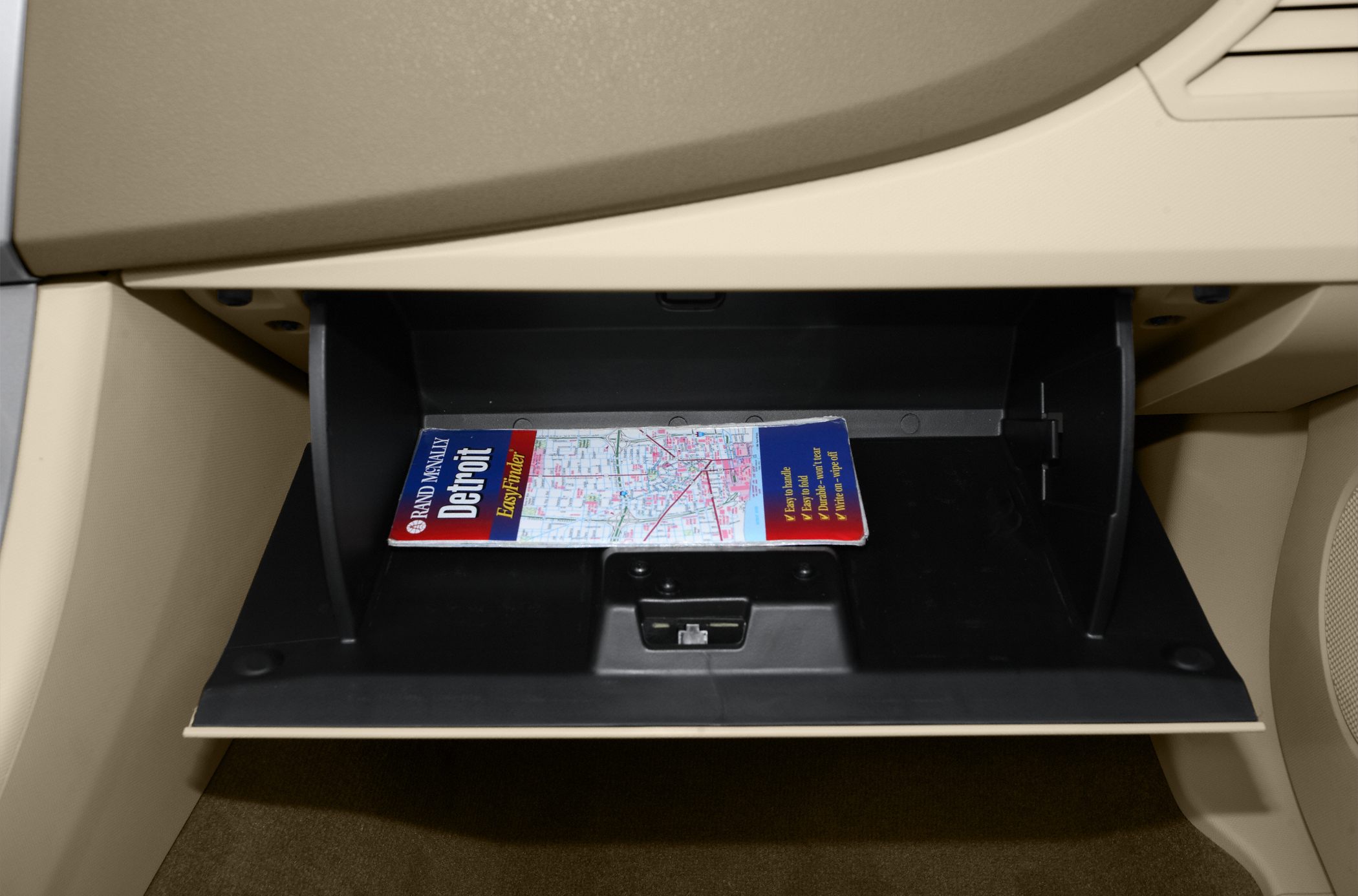 Glove compartment interior with map and beige dashboard