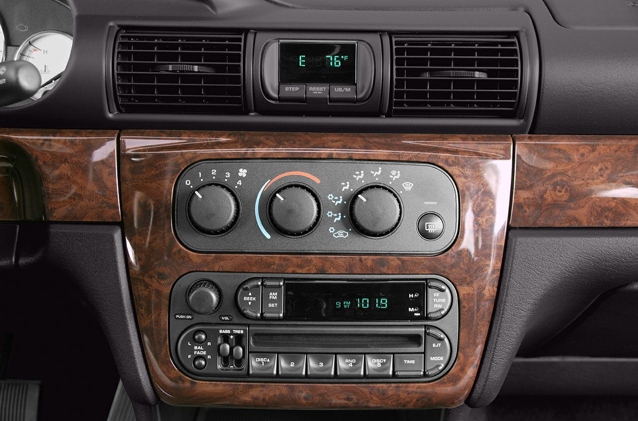 Wood grain dashboard with climate control knobs and AM/FM radio console