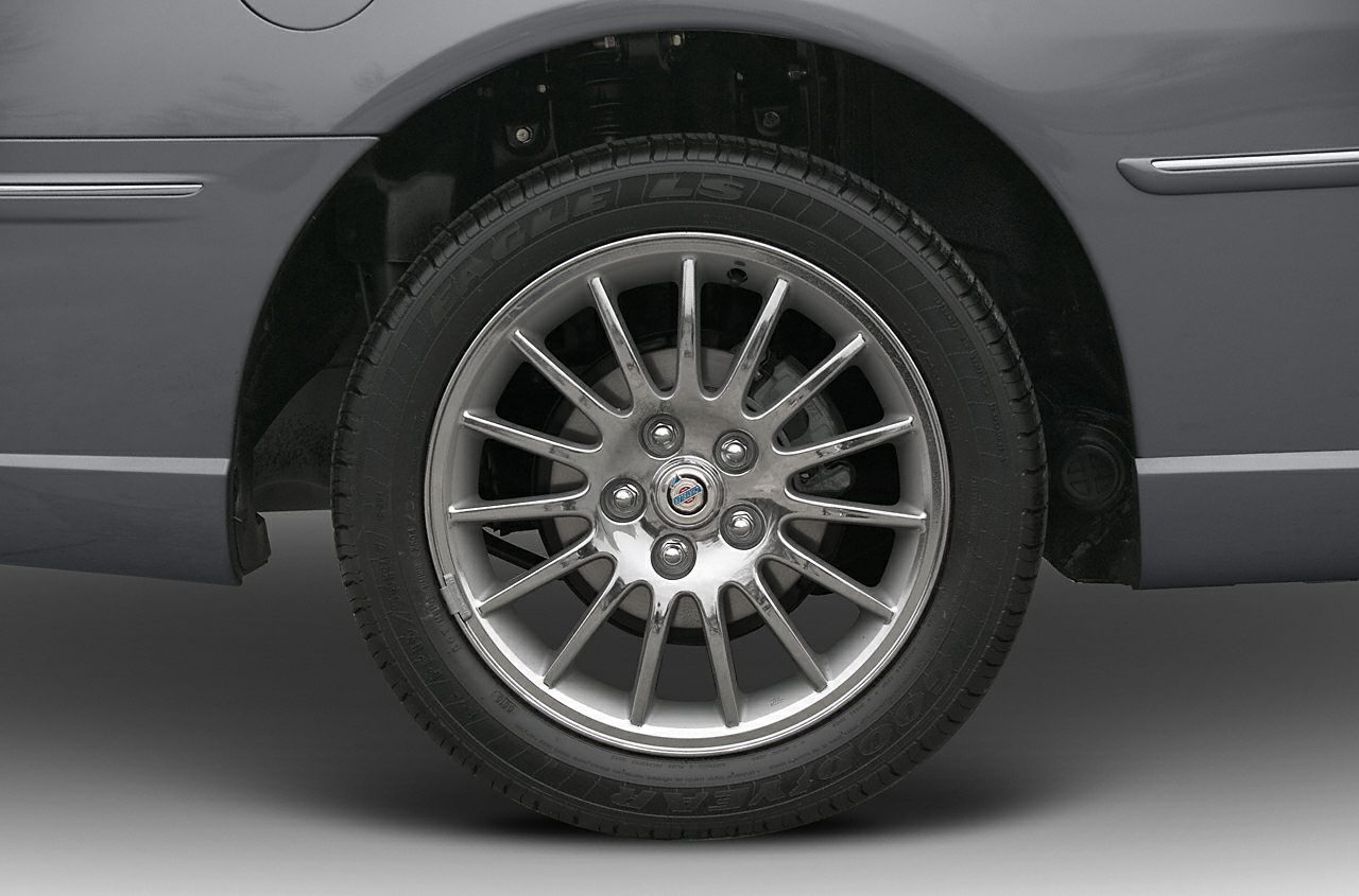 Multi-spoke alloy wheel with tire on car rear side