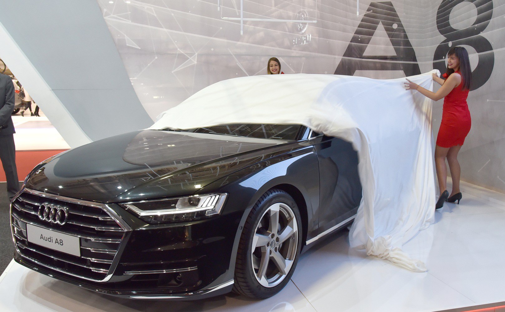 Front grille and LED headlights of a luxury sedan being unveiled