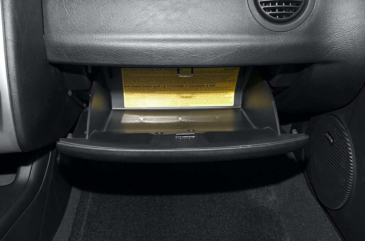 Open glove compartment with airbag system label inside vehicle interior