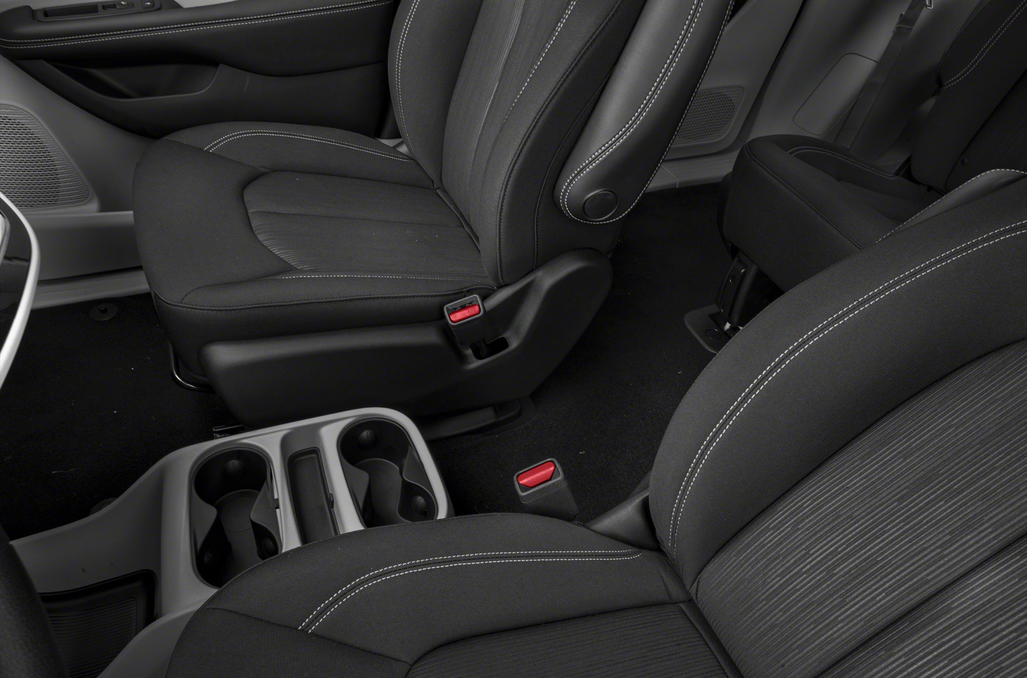 Front seats and central cup holders with detailed upholstery and seatbelt buckles.