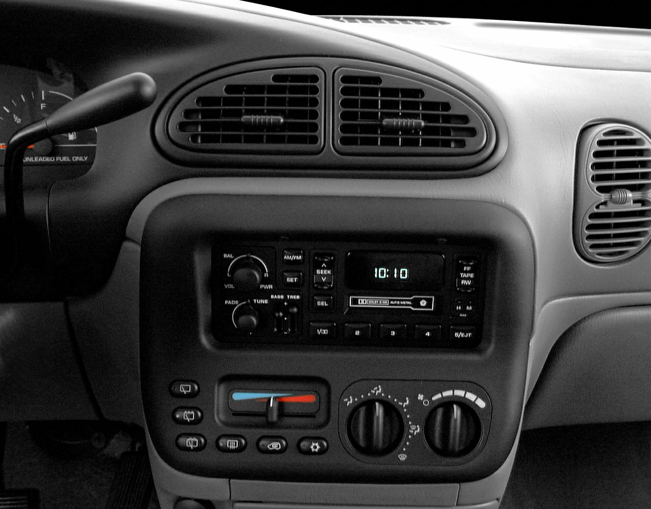 Dashboard radio, cassette player, and climate controls with air vents.