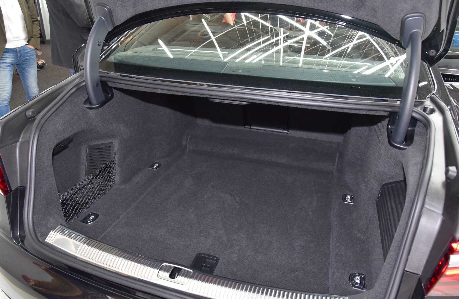 Spacious trunk interior with protective trim and storage net