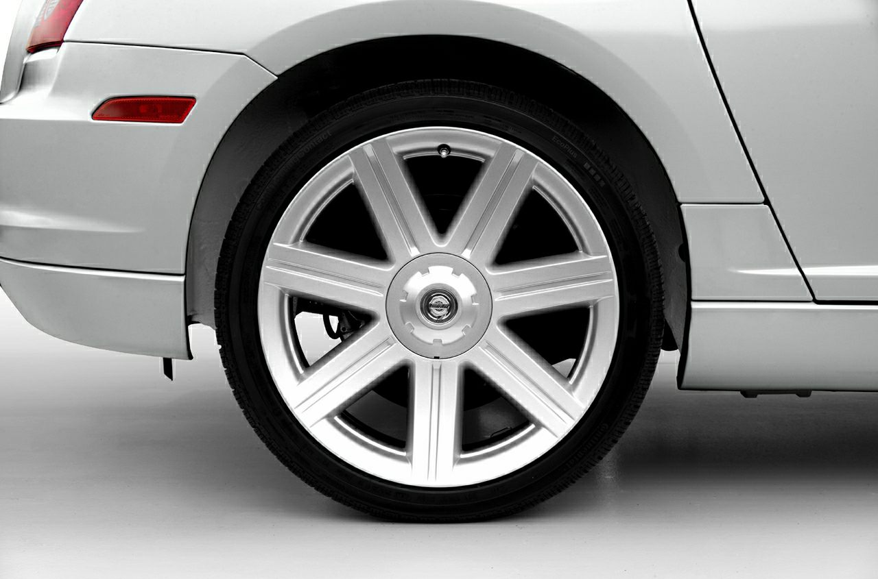 Close-up of silver alloy wheel and tire on a car's rear side.