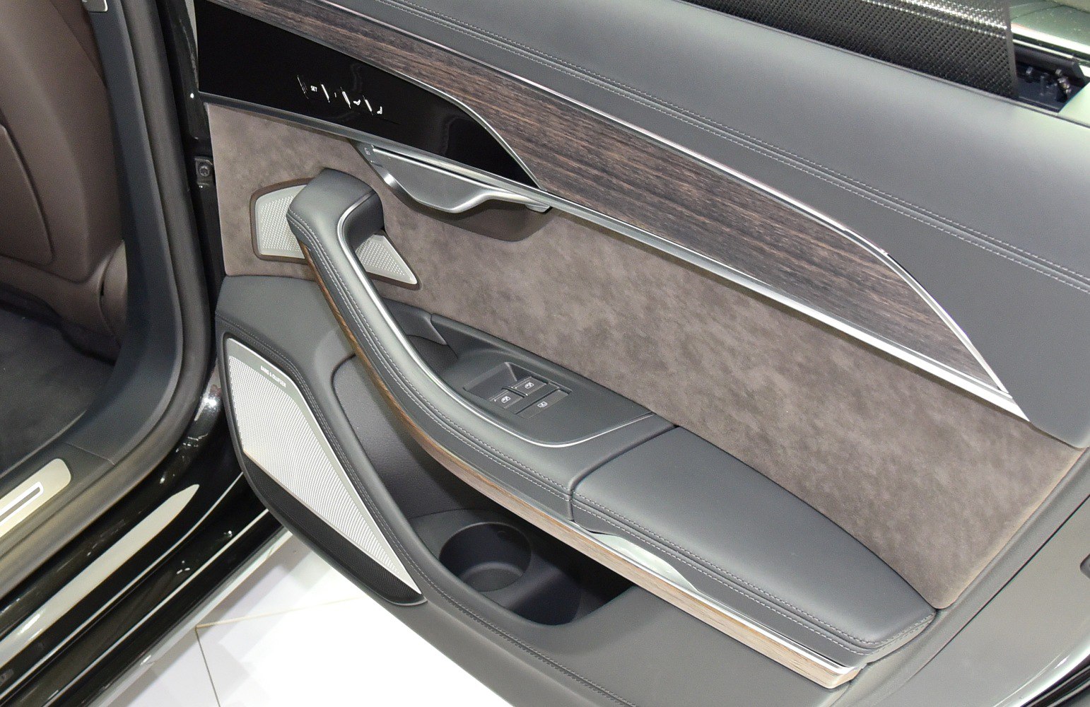 Luxury car door panel with wood trim, leather, and window controls