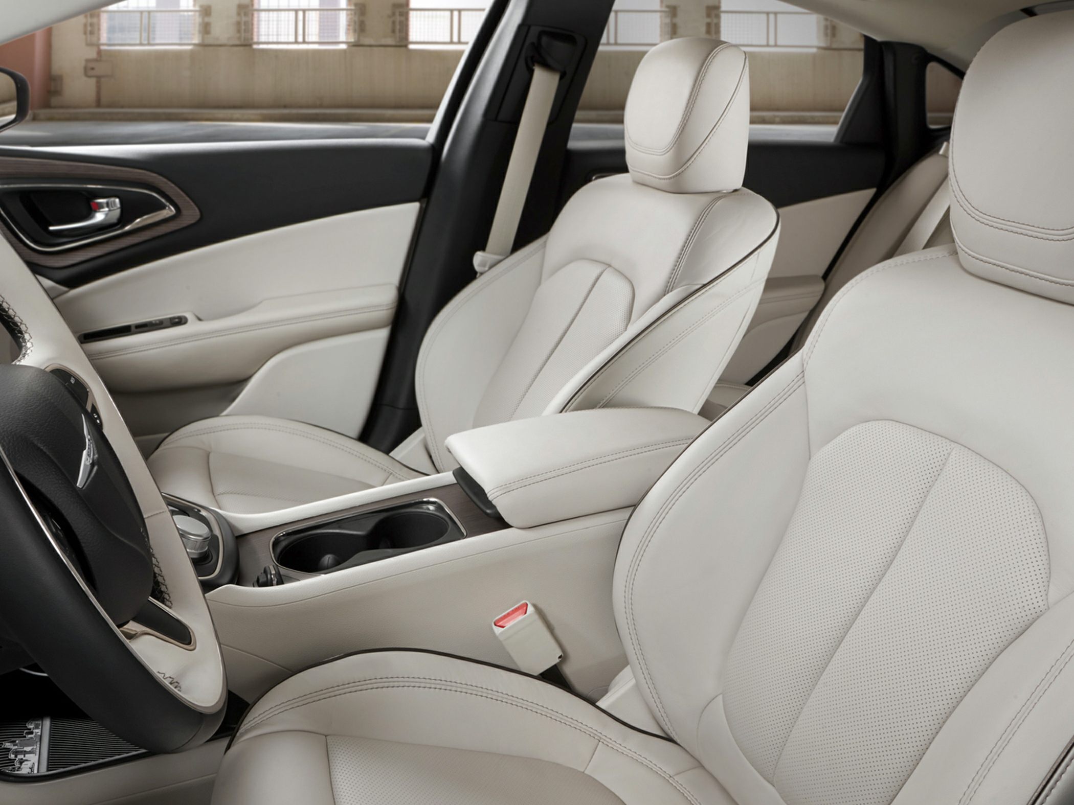 Beige leather seats with detailed stitching and center console with armrest and cup holders
